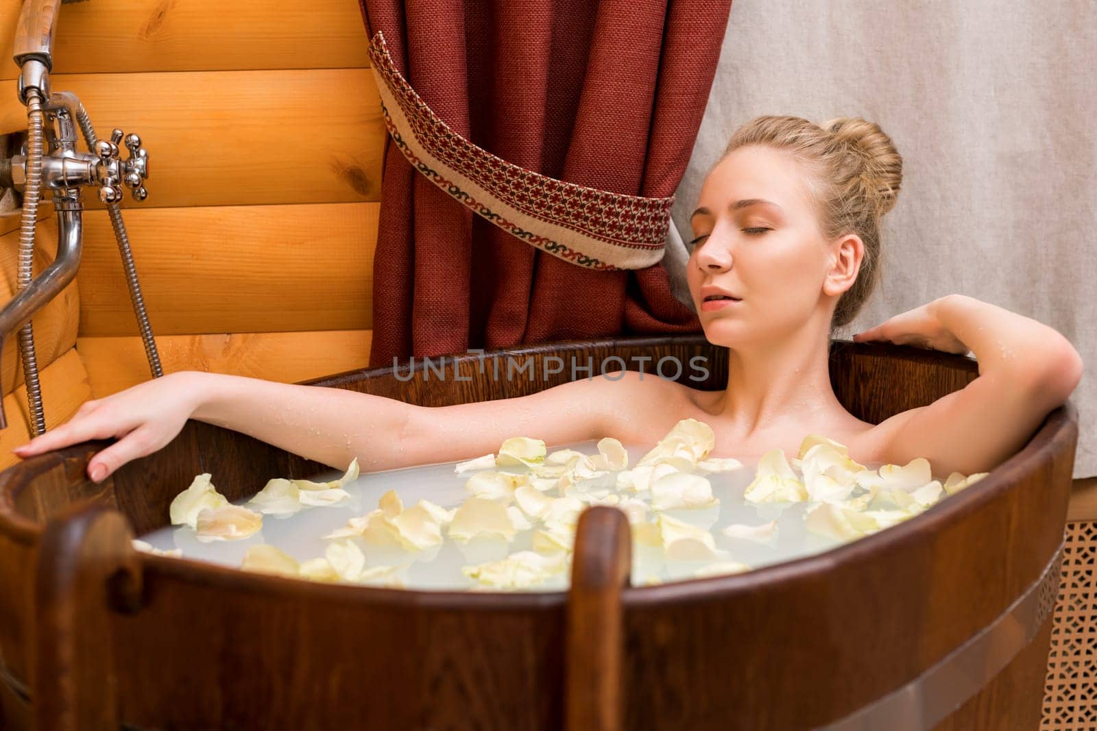 Spa. Girl relaxing in bath with oils and rose petals