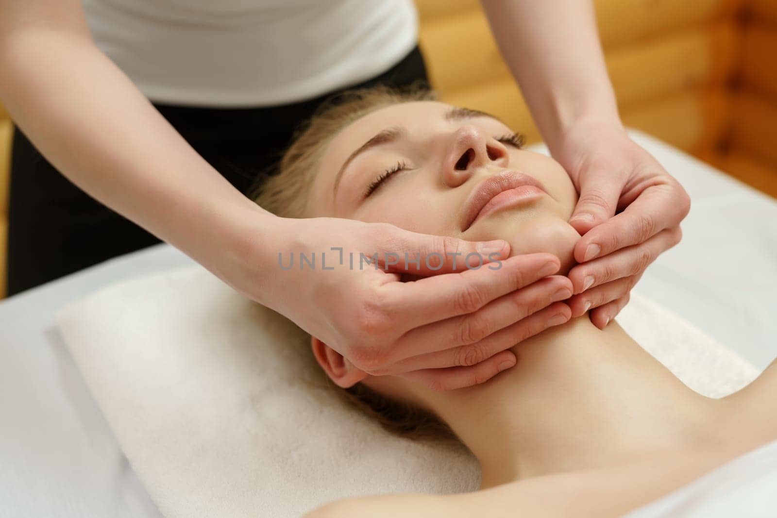 Spa. Massage therapist massaging client's chin, close-up