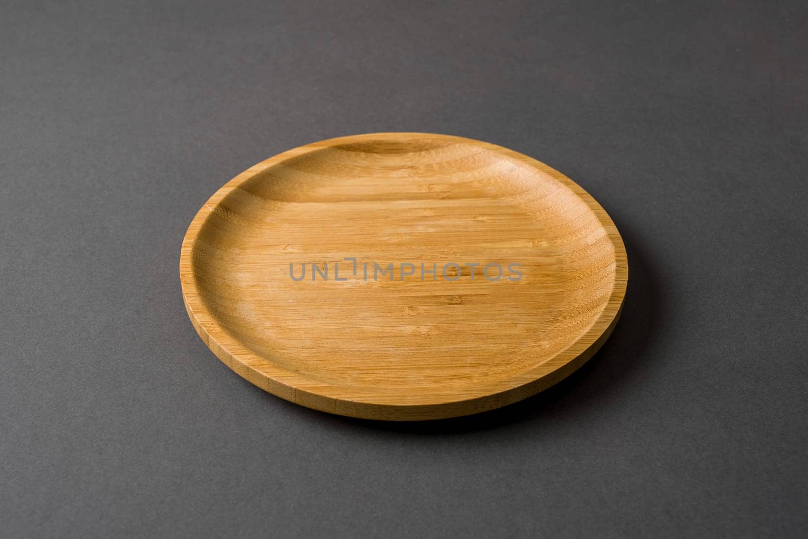 Wooden plate on dark gray background. handmade kitchen utensils