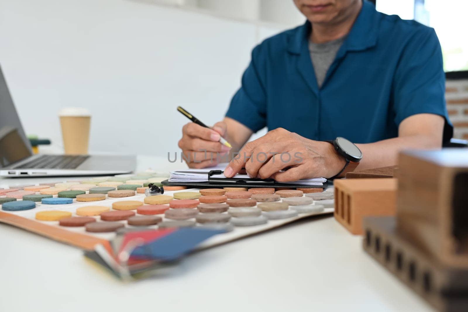 Cropped shot middle age man working on interior design project and choosing materials in studio.