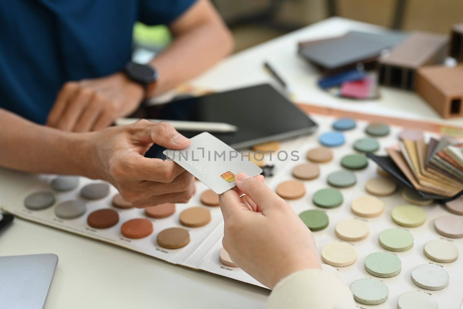 Cropped shot of female costumer making payment with credit card with contractor for services.