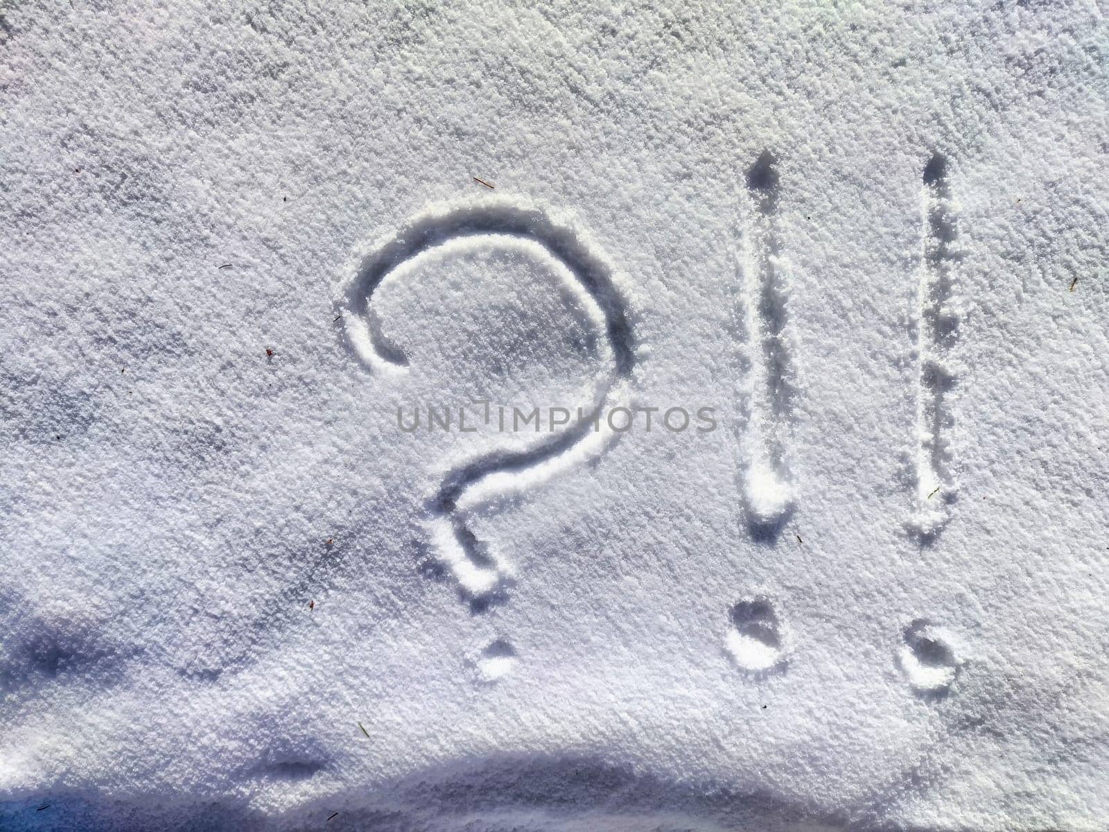 A large question mark is etched into the fresh snow, creating a stark contrast against the white surface on a serene winter morning.