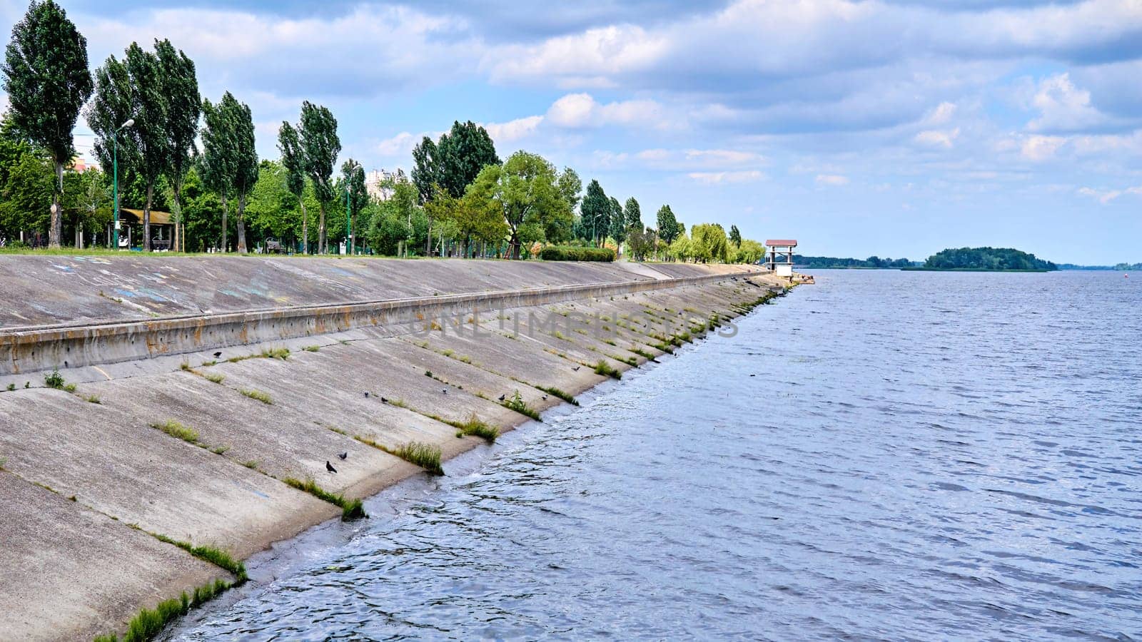 Stone river embankment overgrown with green bushes by jovani68