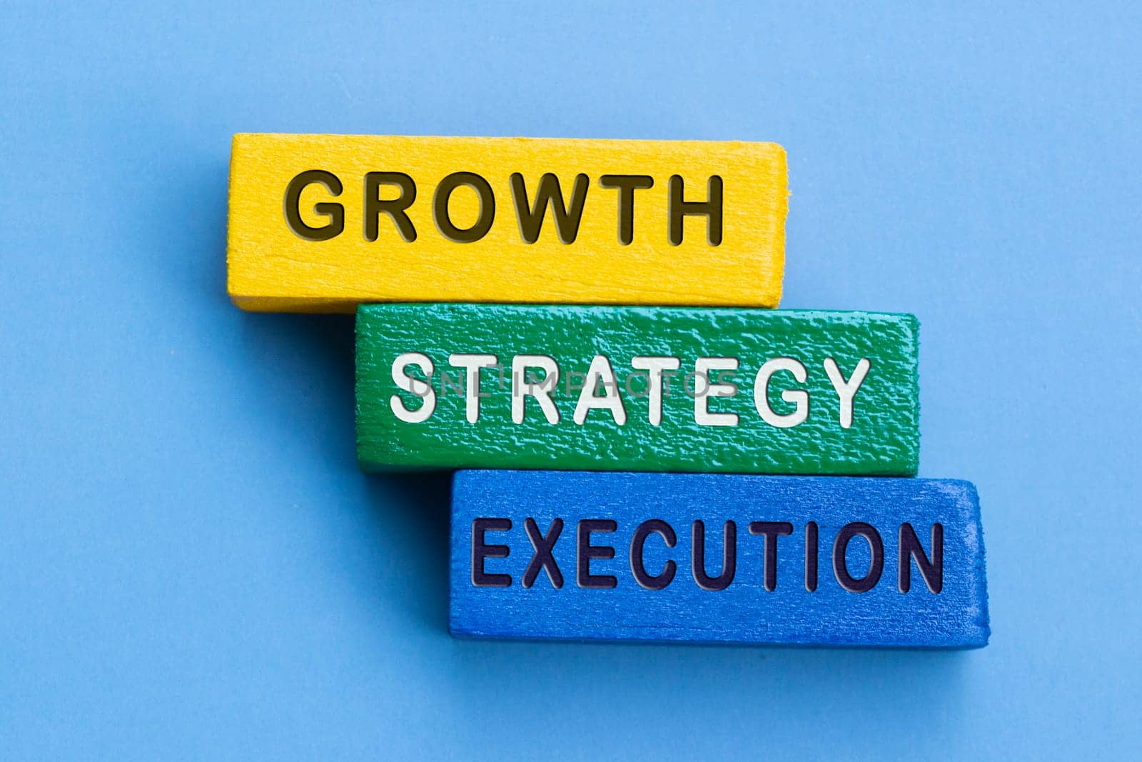 Colorful blocks with word growth, strategy and execution on blue background. Business concept.