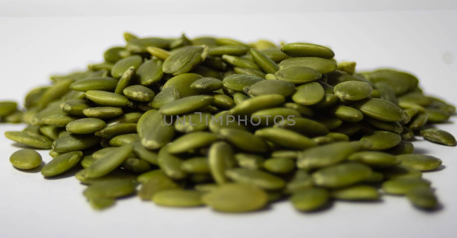 Close up pile of pumpkin seeds ,isolated. White background. Healthy food. by VeroDibe