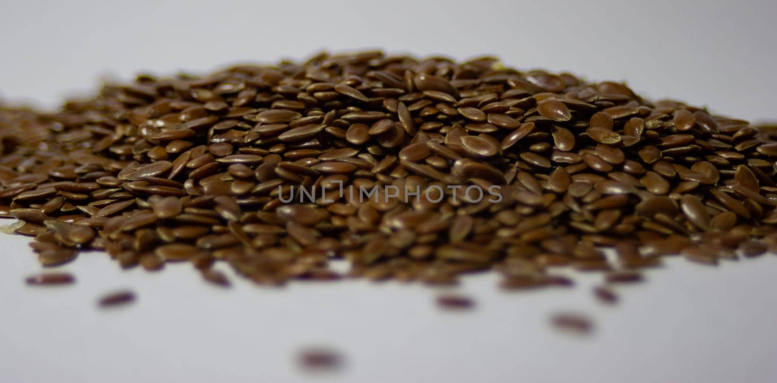 Horizontal picture of a pile of linseed with white background.Healthy food. by VeroDibe