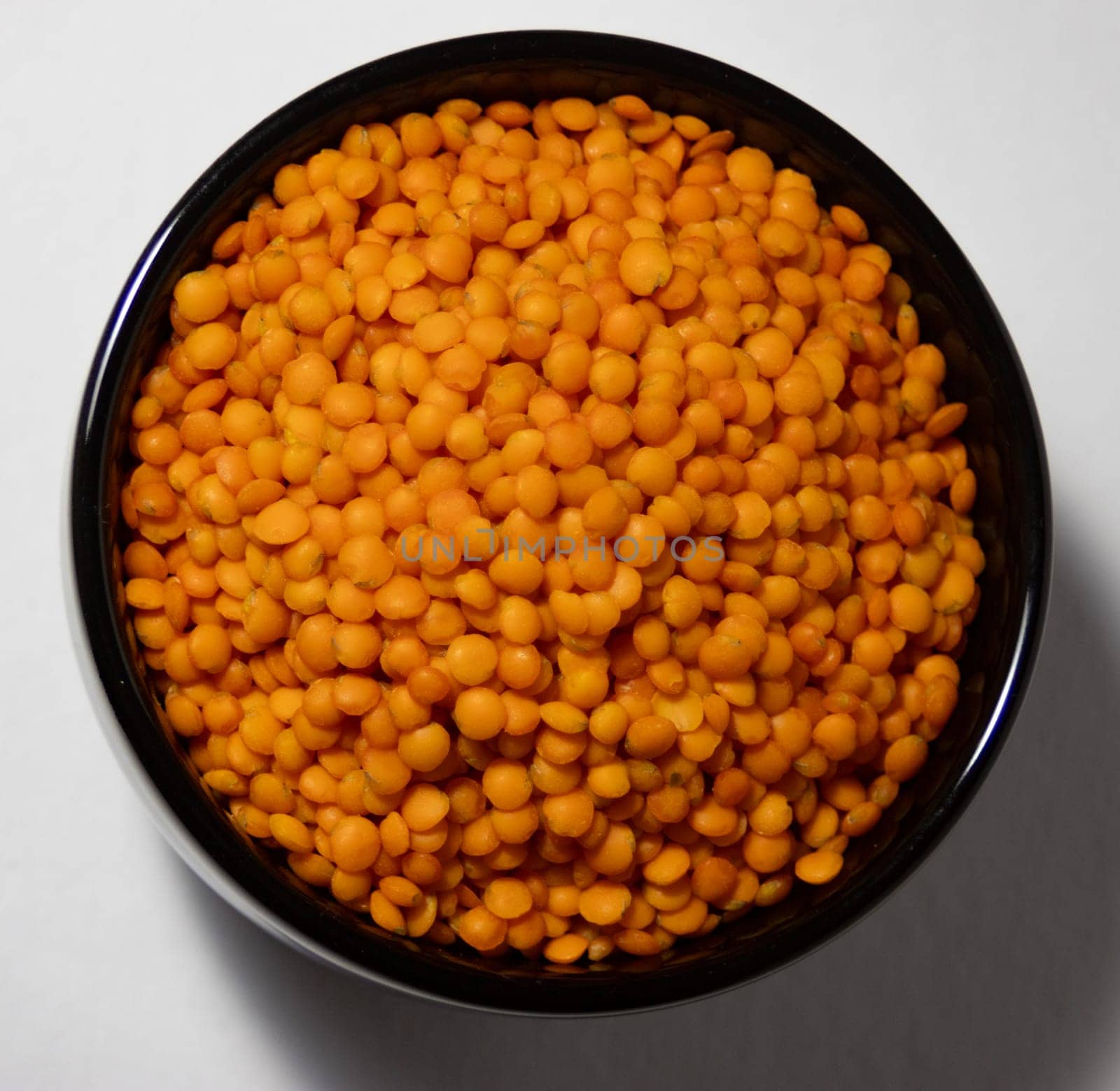 Zenithal photo of red lentils with white background .Healthy legumes by VeroDibe