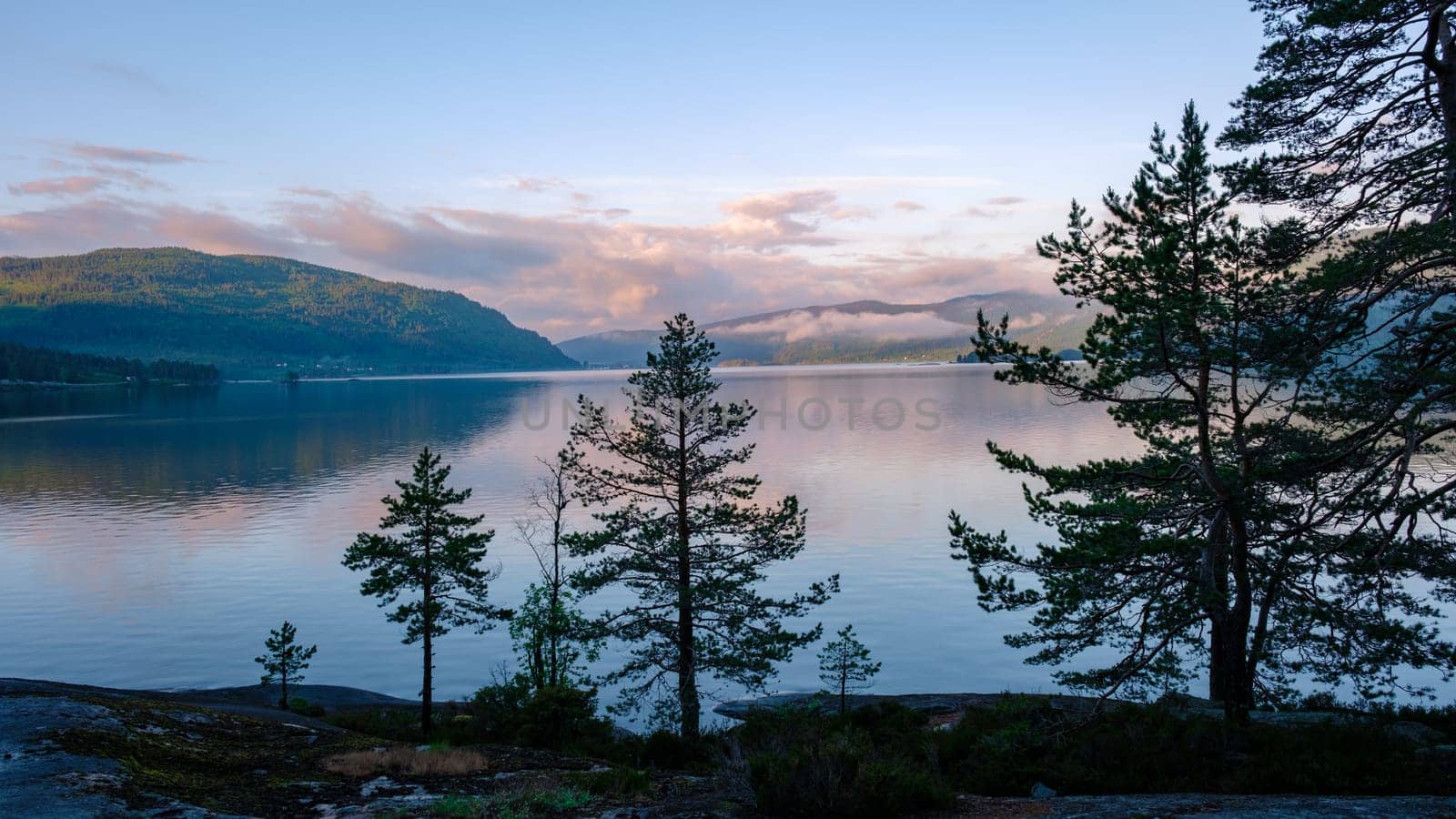 Byglandsfjord Lake with trees in Norway is, a beautiful mountain lake at sunrise