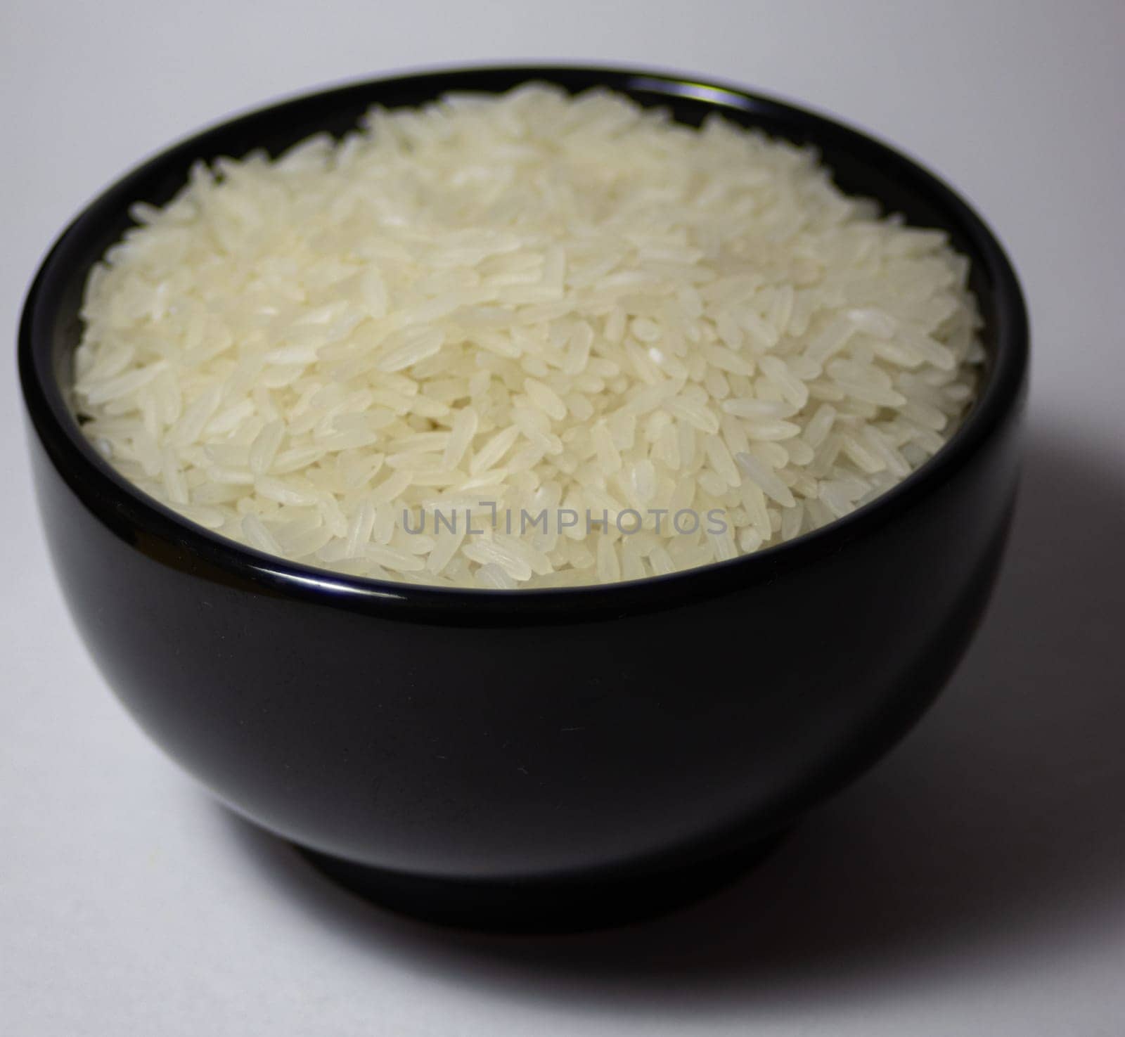 Rice grains in a black dish.Carbohydrate source. Healthy food concept. Vegan food