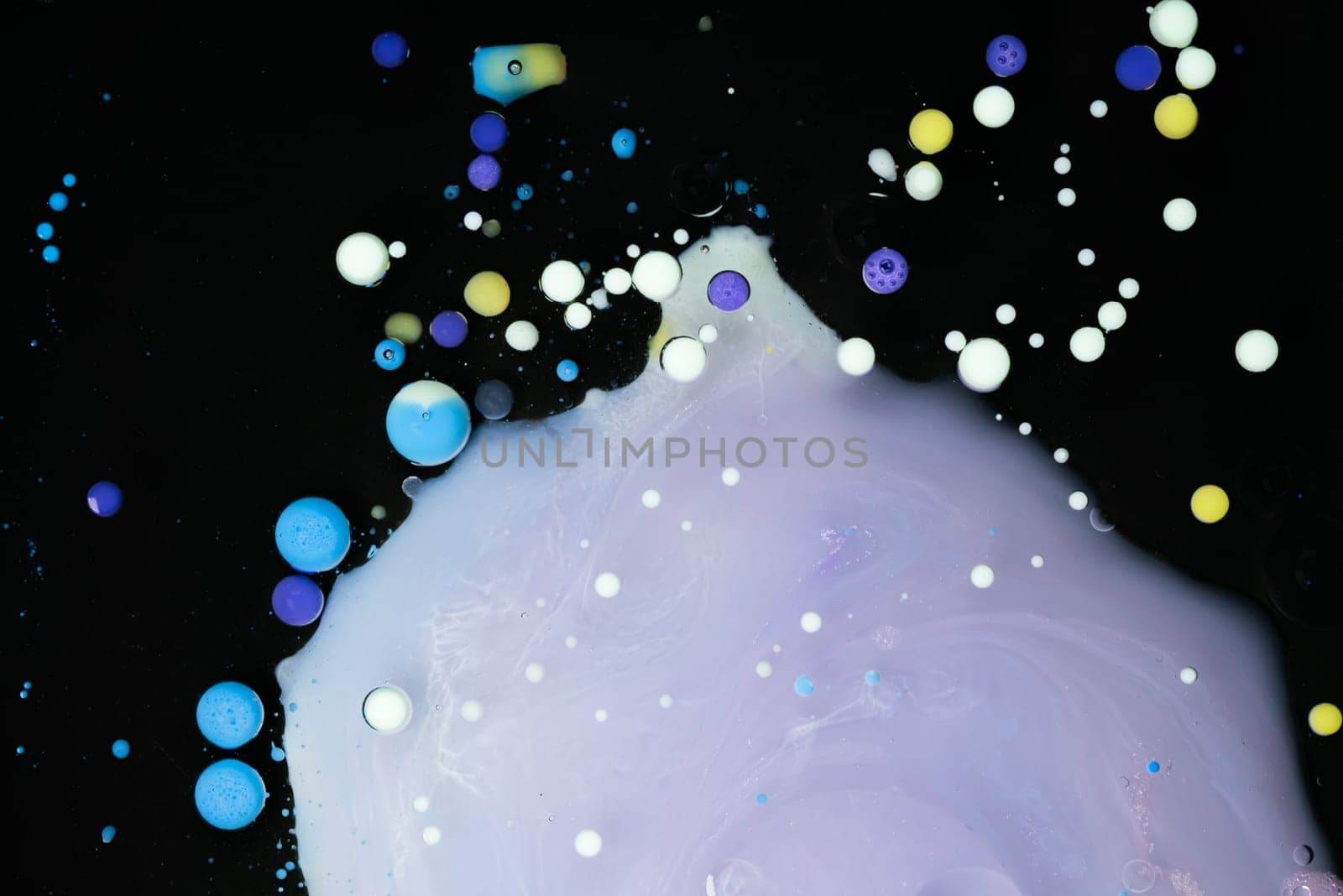 A myriad of oil droplets intermingling with water, creating a mesmerizing effect reminiscent of a galaxy.