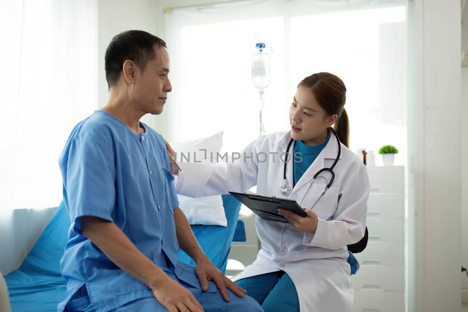 Female doctor consulting senior male patient in hospital. Healthcare and medical concept in Asian..