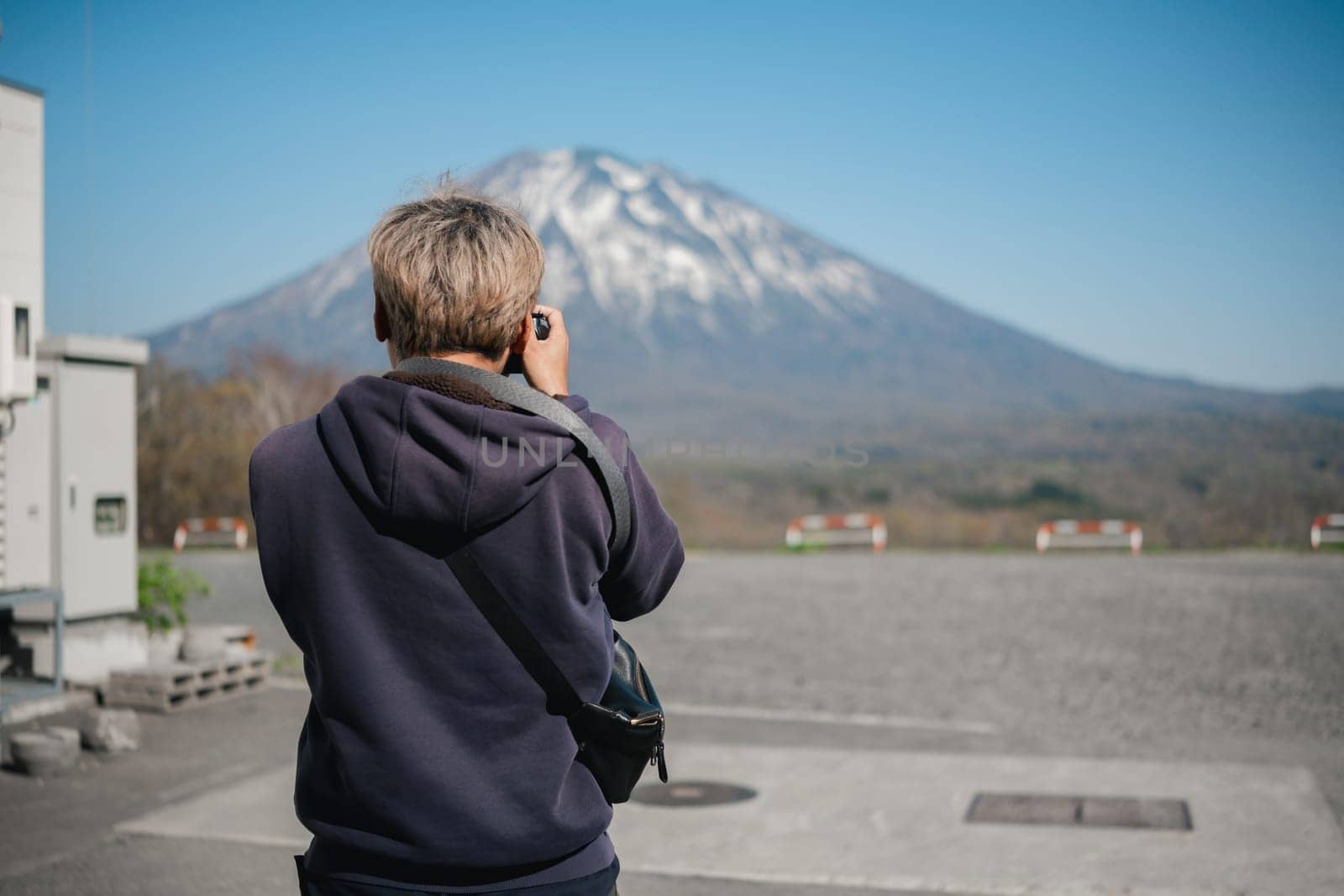 Person photographing a mountain in outdoor setting. Concept of travel and nature photography.