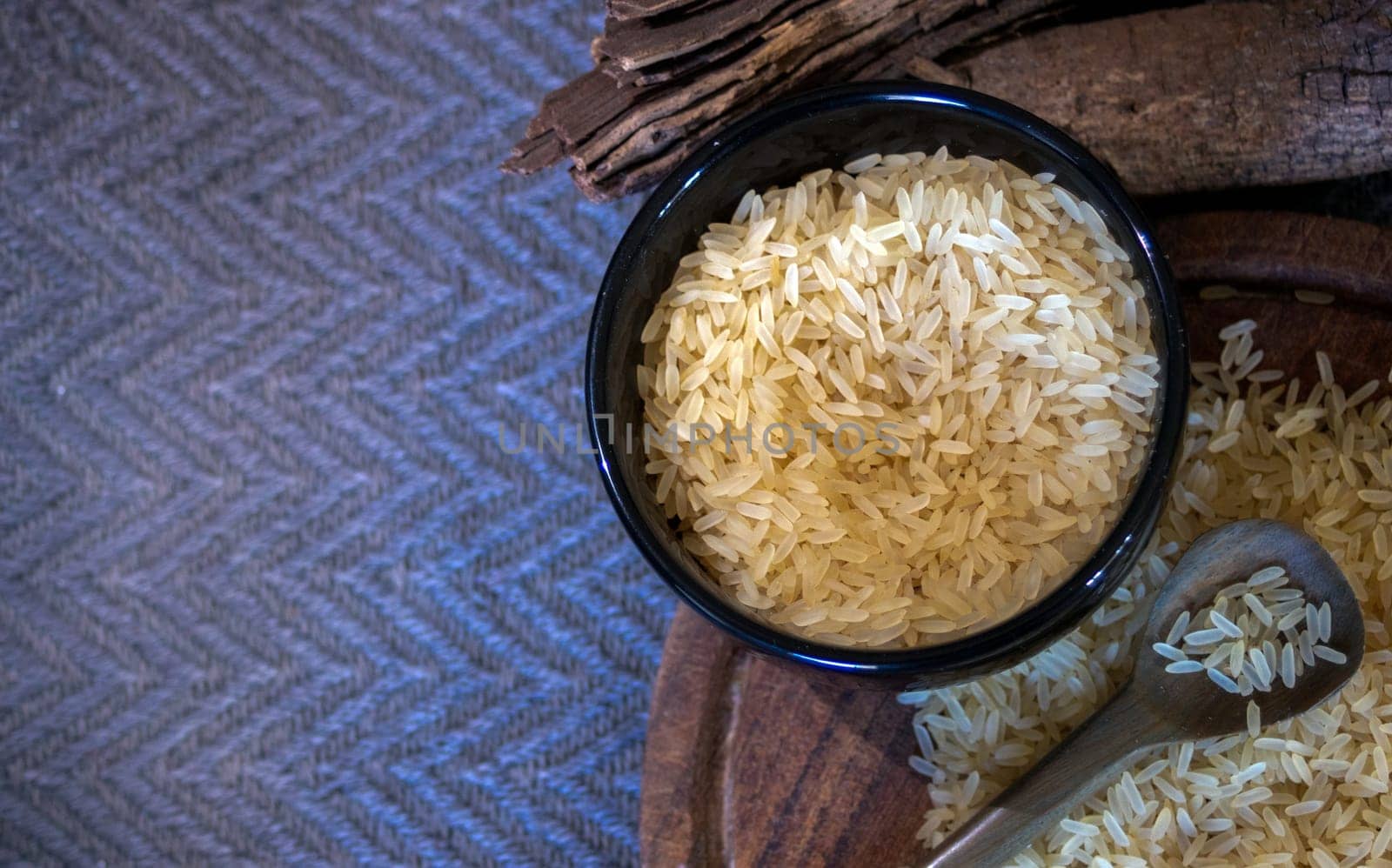 Cenital picture of yellow rice grains on a wooden board. Space for text. by VeroDibe