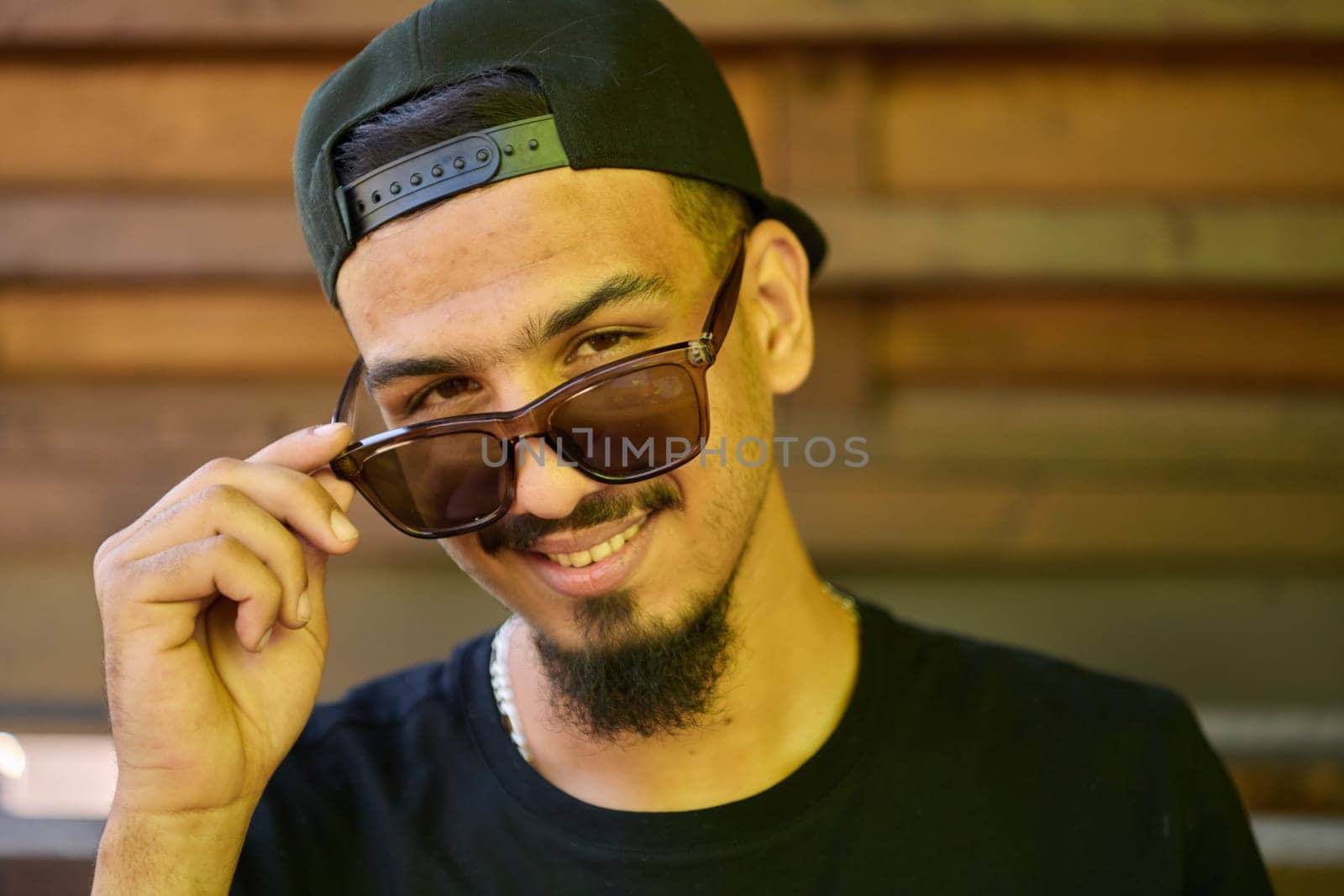 A striking close-up shot capturing the radiant smile of a Sudanese teenager, complemented by a chin and stylish cap.