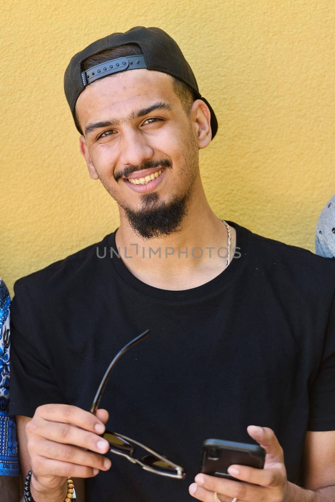 Close Up Portrait of Smiling Sudanese Teenager with Broad Smile, Chin, and Cap Using Smartphone by dotshock