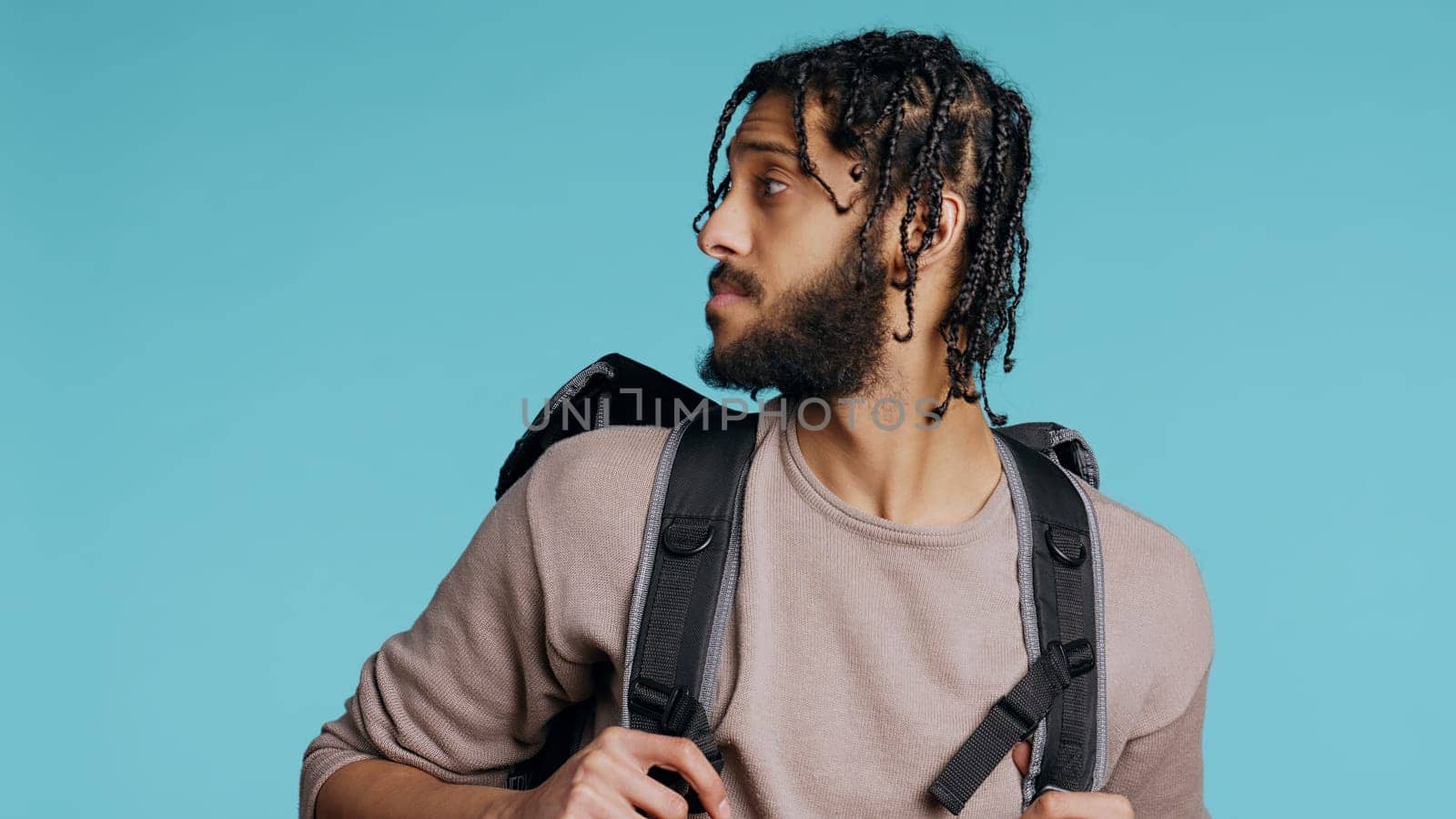 Portrait of cheerful courier waving hand, greeting client, bringing pizza box. Happy delivery part time employee using thermal backpack to bring food order to customer, studio background, camera B