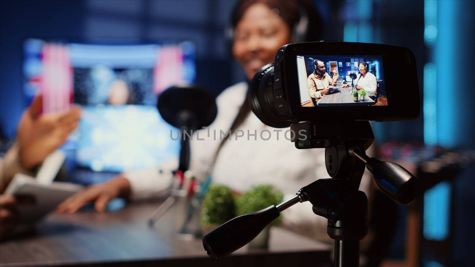 Professional camera recording man in blurry background interviewing guest by DCStudio