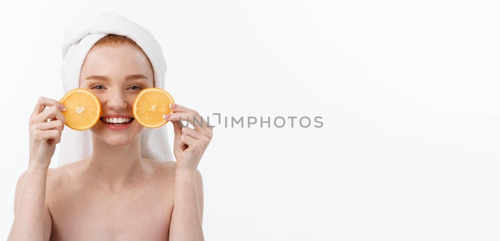 Great food for a healthy lifestyle. Beautiful young shirtless woman holding piece of orange standing against white background. by Benzoix
