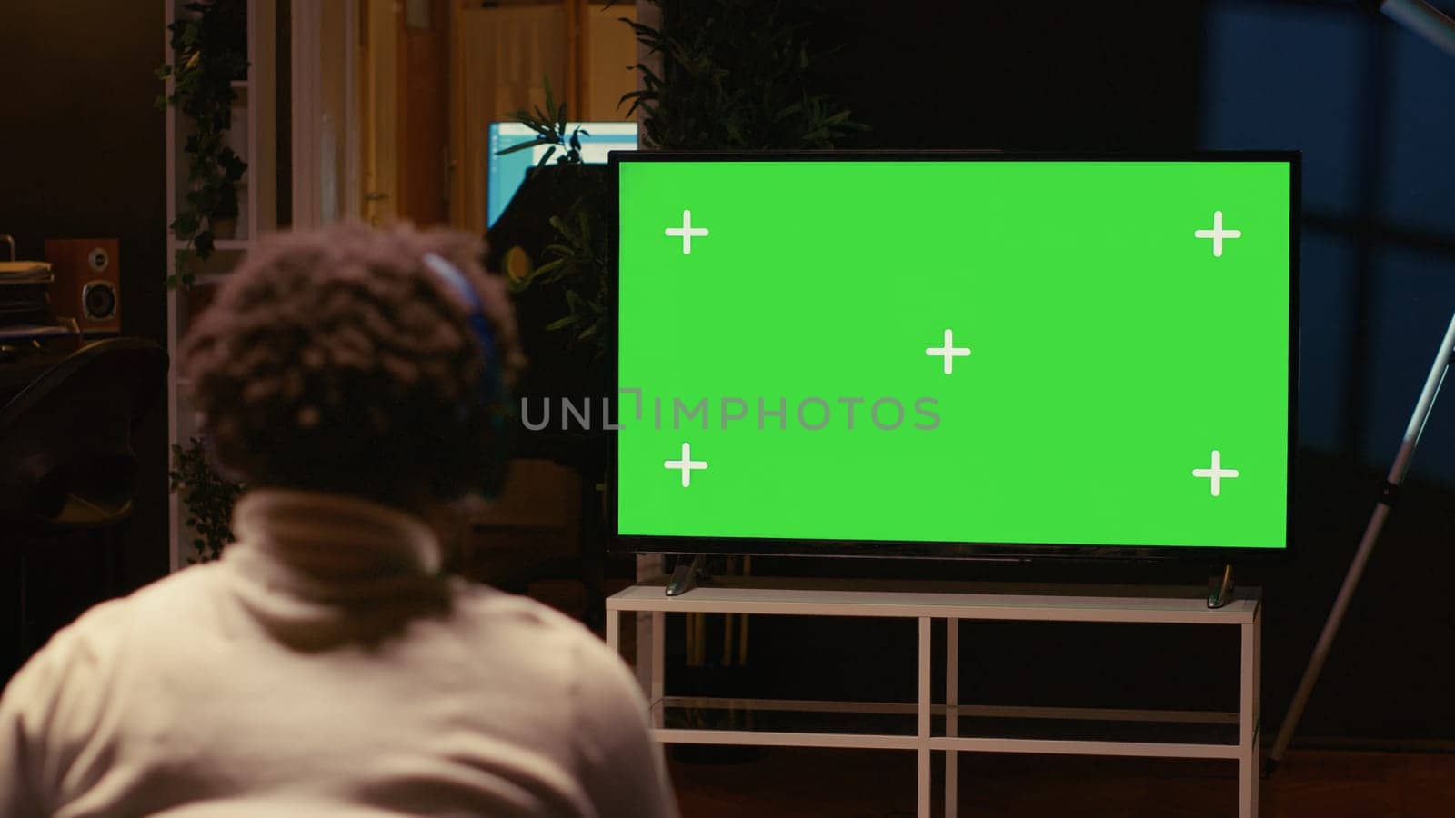 Man playing singleplayer videogames on green screen TV in cozy living room by DCStudio