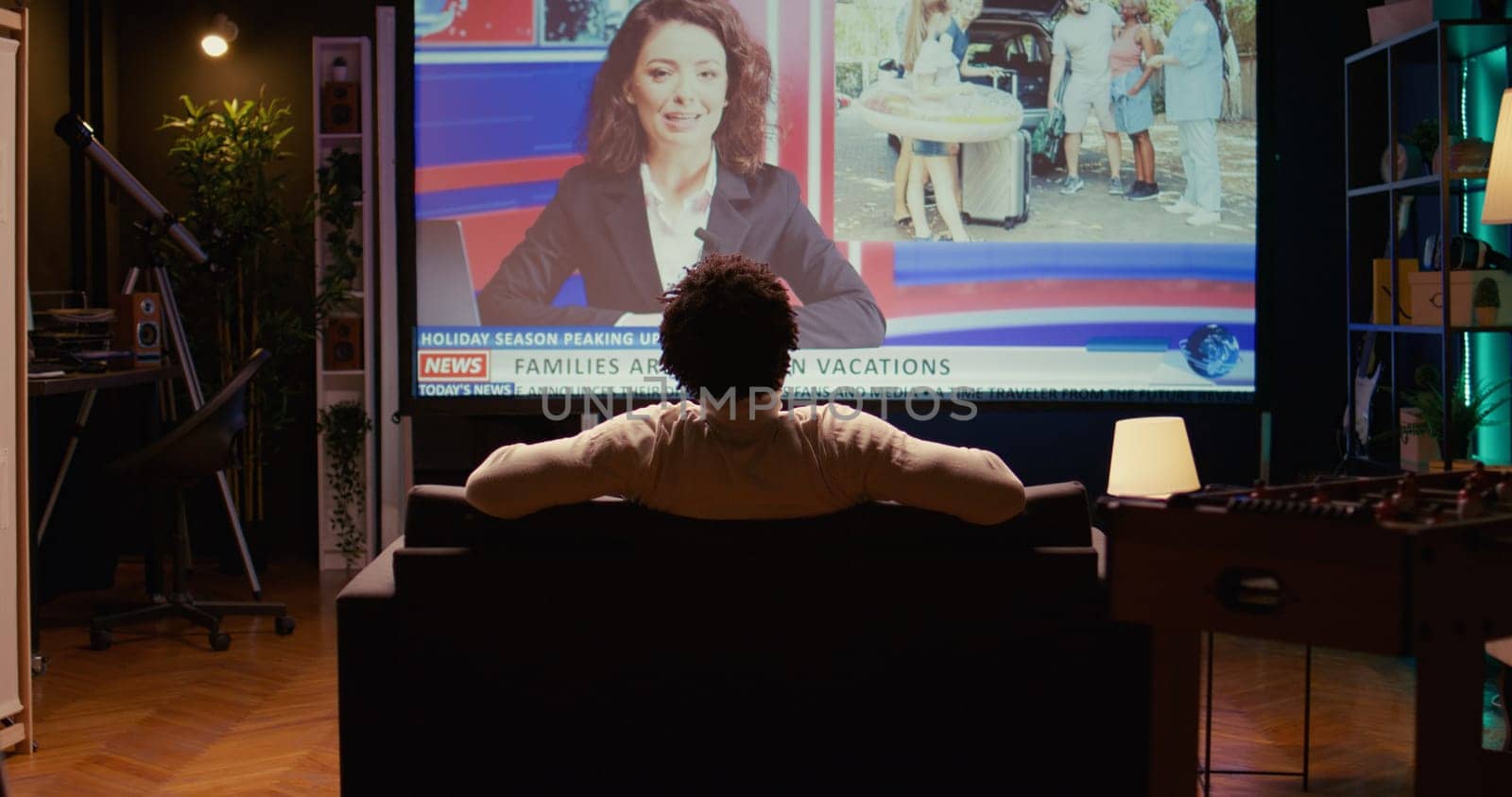 Man in home theatre watching huge TV screen showing news broadcast reportages on family trips. Zoom in shot on cord cutter looking at streaming service travelling channel on widescreen television set