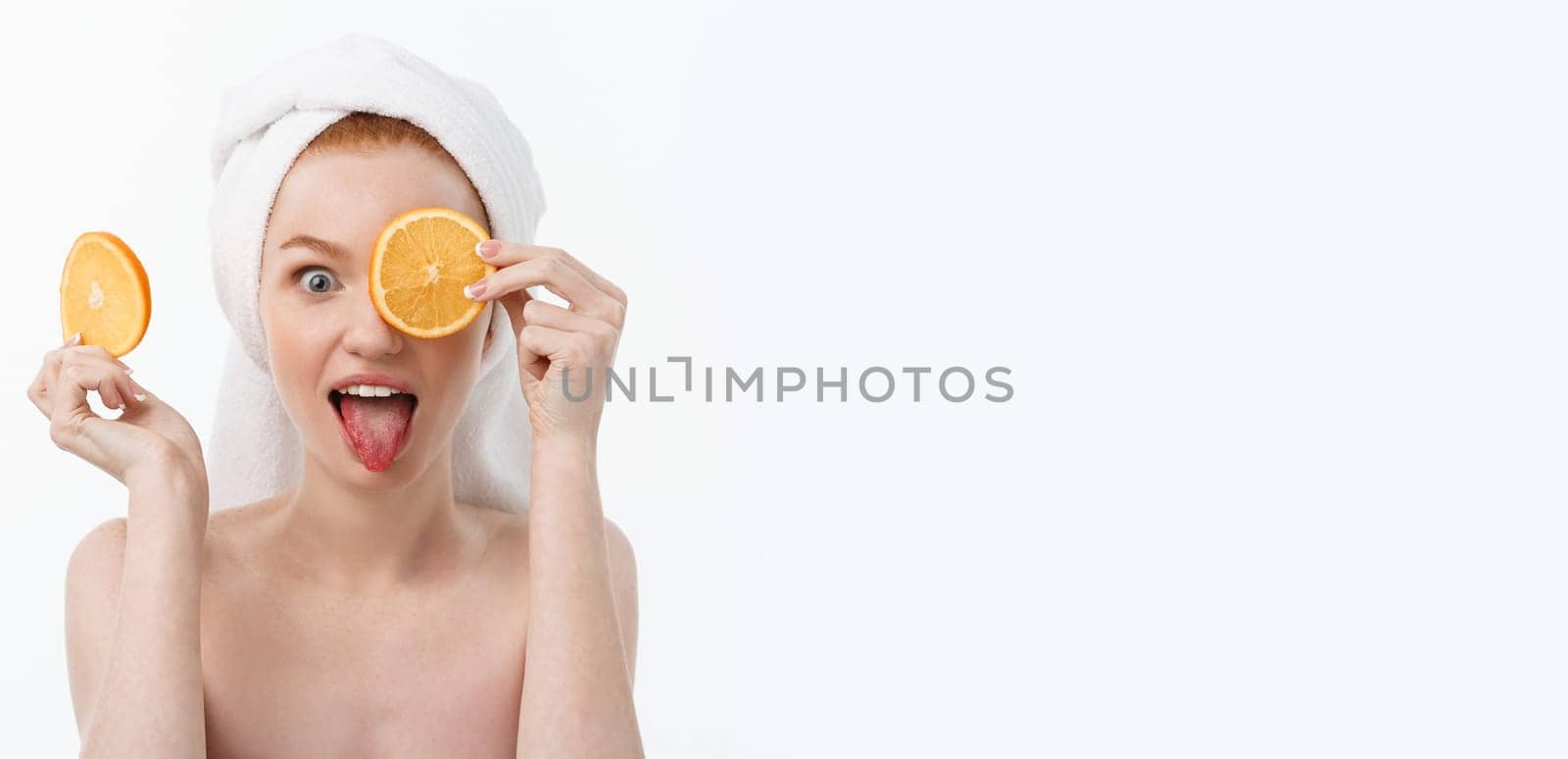 Great food for a healthy lifestyle. Beautiful young shirtless woman holding piece of orange standing against white background. by Benzoix