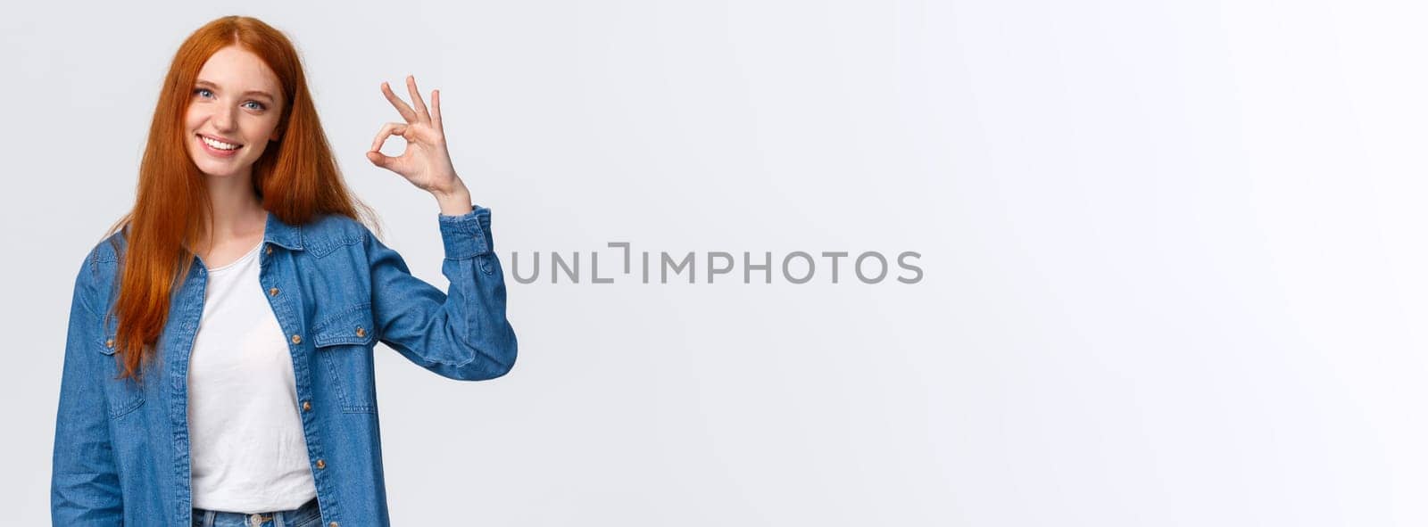 Teamwork, communication and people concept. Supportive good-looking female team member, girl coworker showing okay gesture and smiling with approval, agree or like something, white background.
