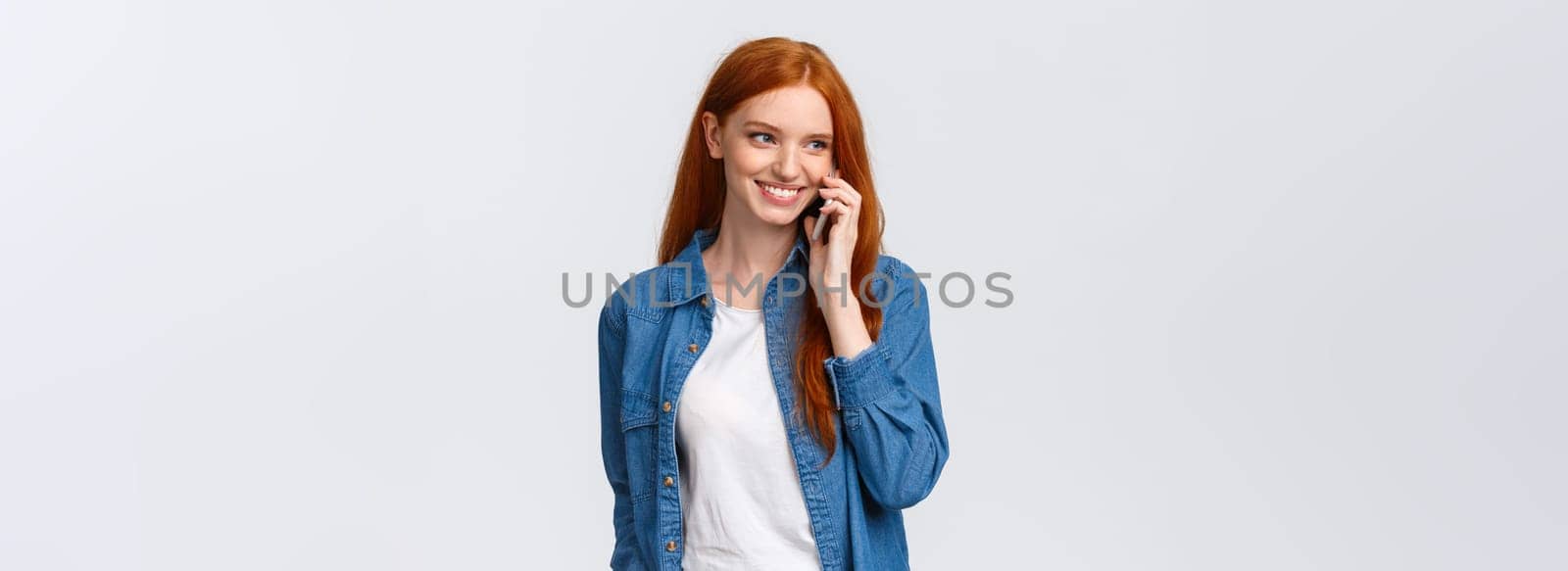 Girl calling boyfriend pick her up after classes. Attractive outgoing redhead woman talking on phone, smiling carefree, look away as having casual conversation on smartphone, white background.