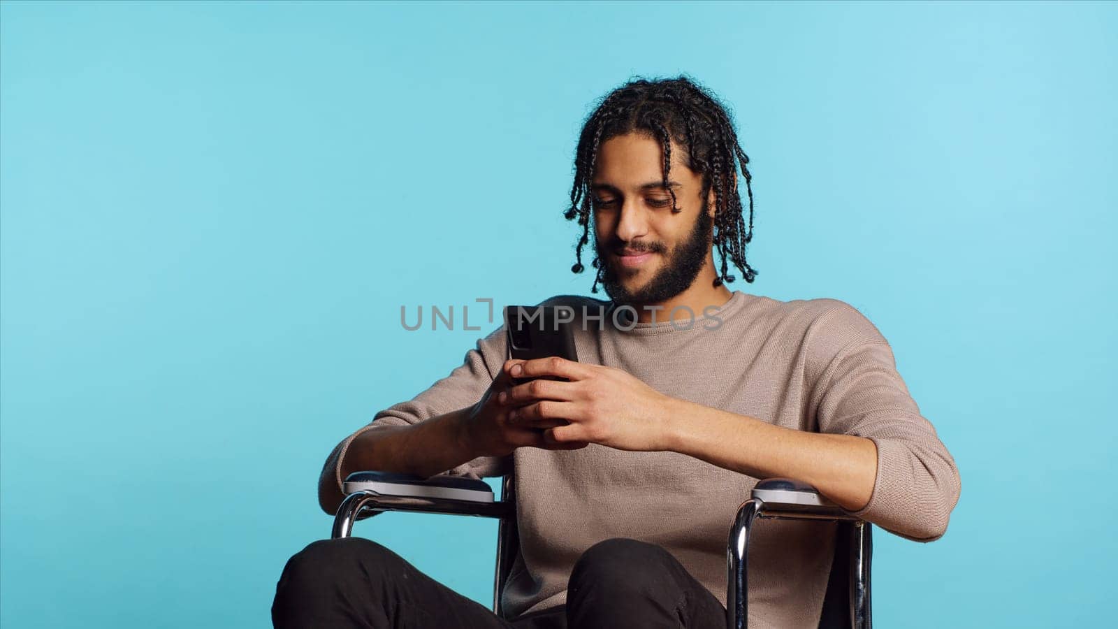 Person with paraplegia talking with mate in video call, studio background by DCStudio