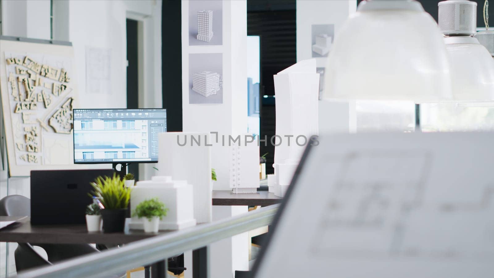 Empty engineering office equipped with industrial gear and architectural details, shared workspace area for startup company. 3D construction models, project plans and visual program tools.