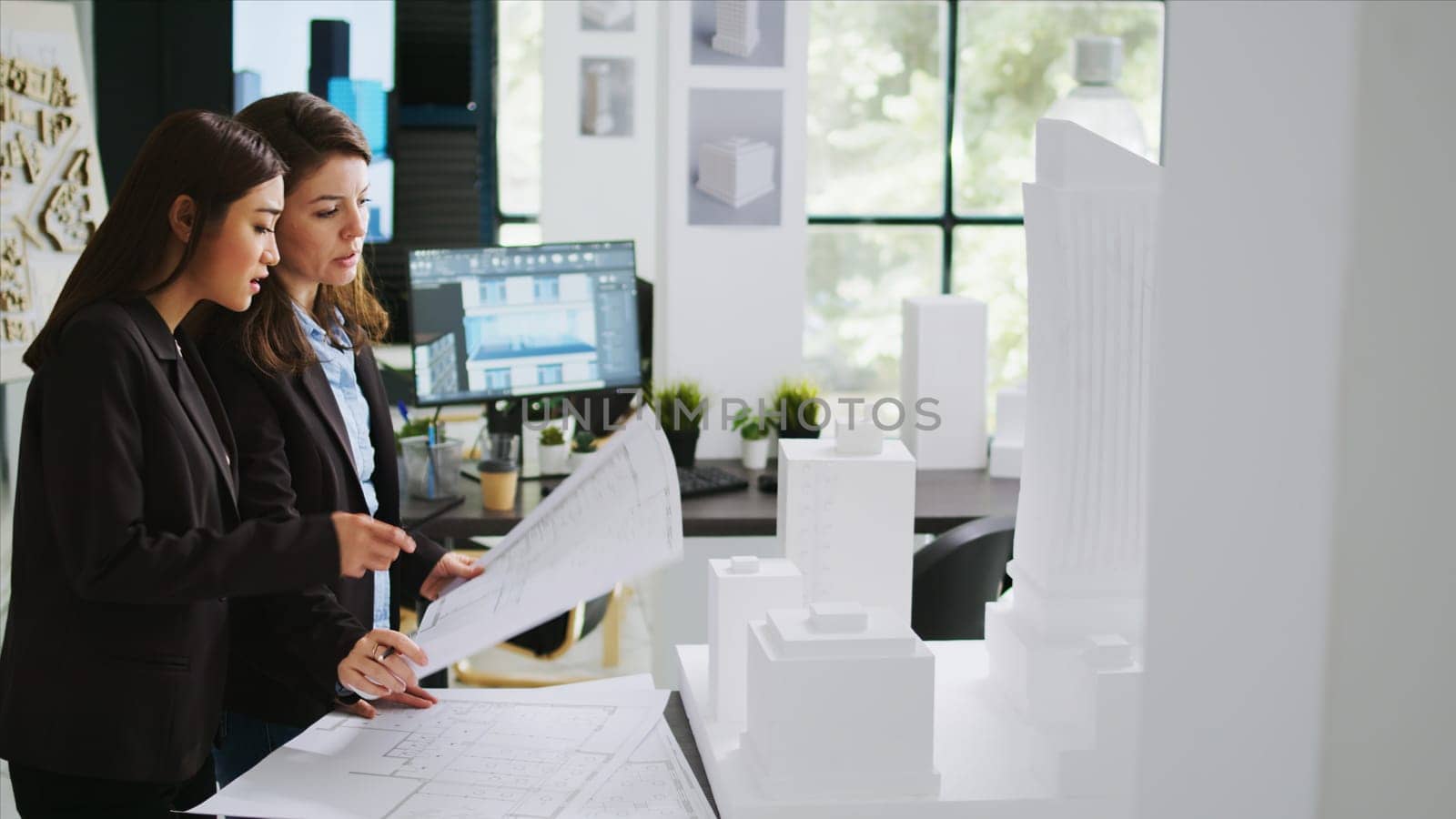 Architects team studying 3d printed building model in office by DCStudio