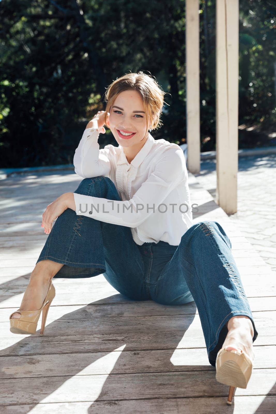 a beautiful woman in jeans sitting on the floor on the street walk