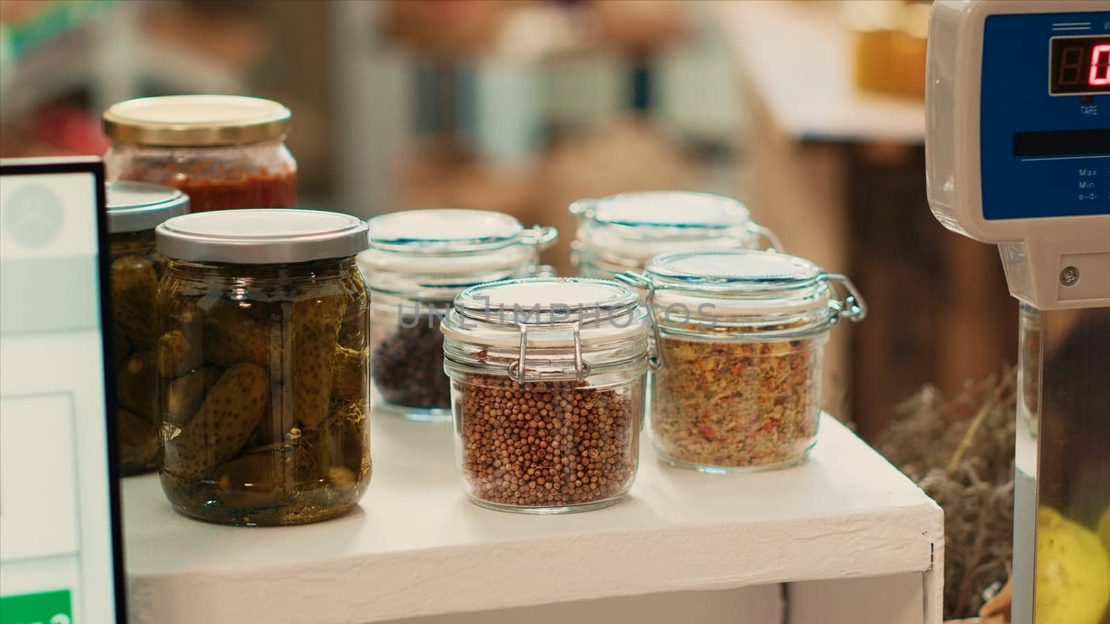 Cereals and grains in reusable jars placed on checkout counter at local eco supermarket, low carbon footprint locally grown merchandise. Organic fresh chemicals free products in store. Close up.