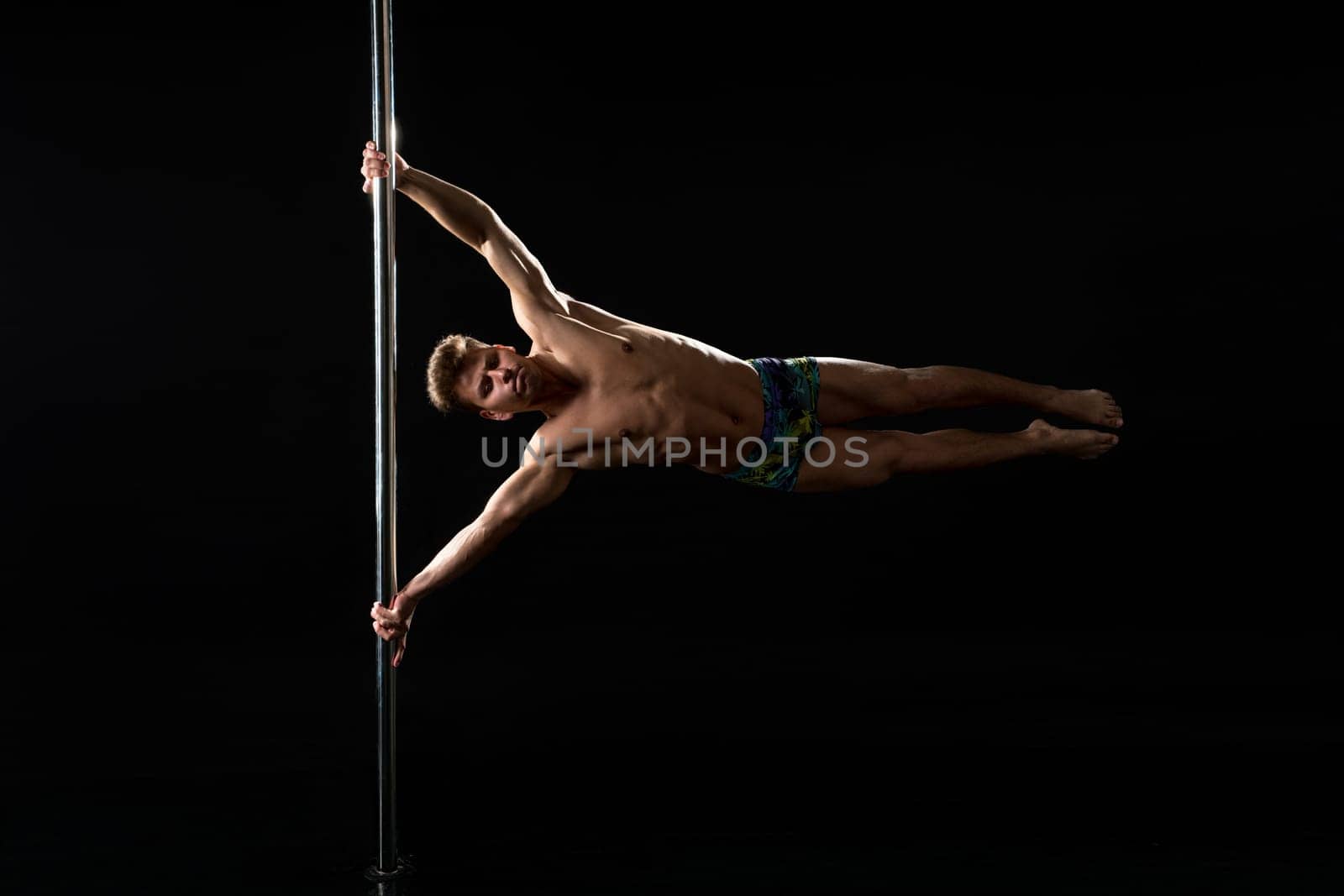 Male pole dance. Image of dancer with strained face