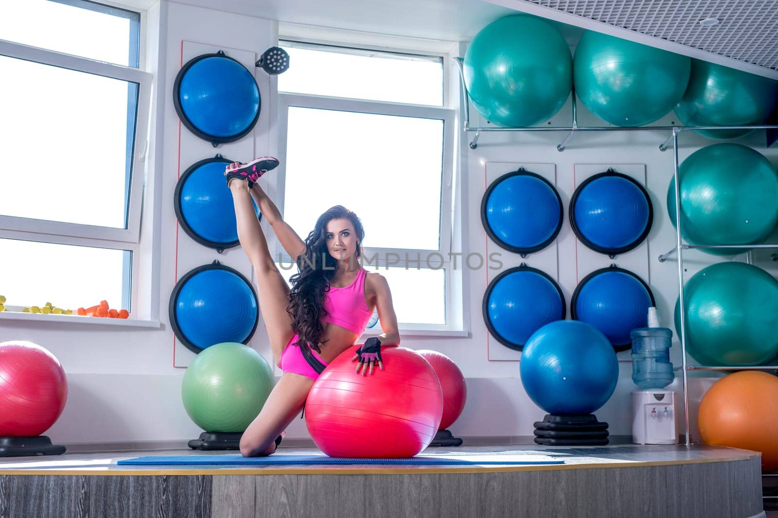 Image of beautiful sporty woman trains in modern gym