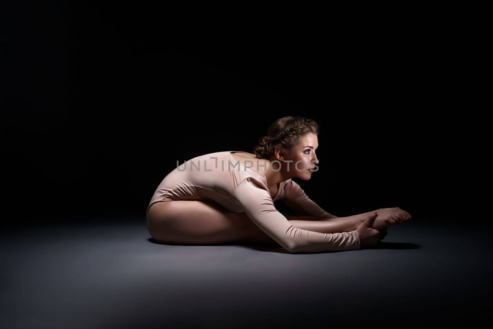 Studio photo of purposeful gymnast training, on gray background