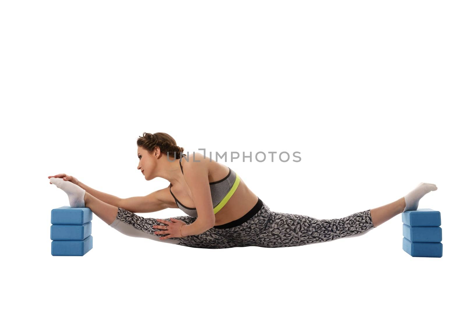 Image of woman doing stretching using gymnastic bricks