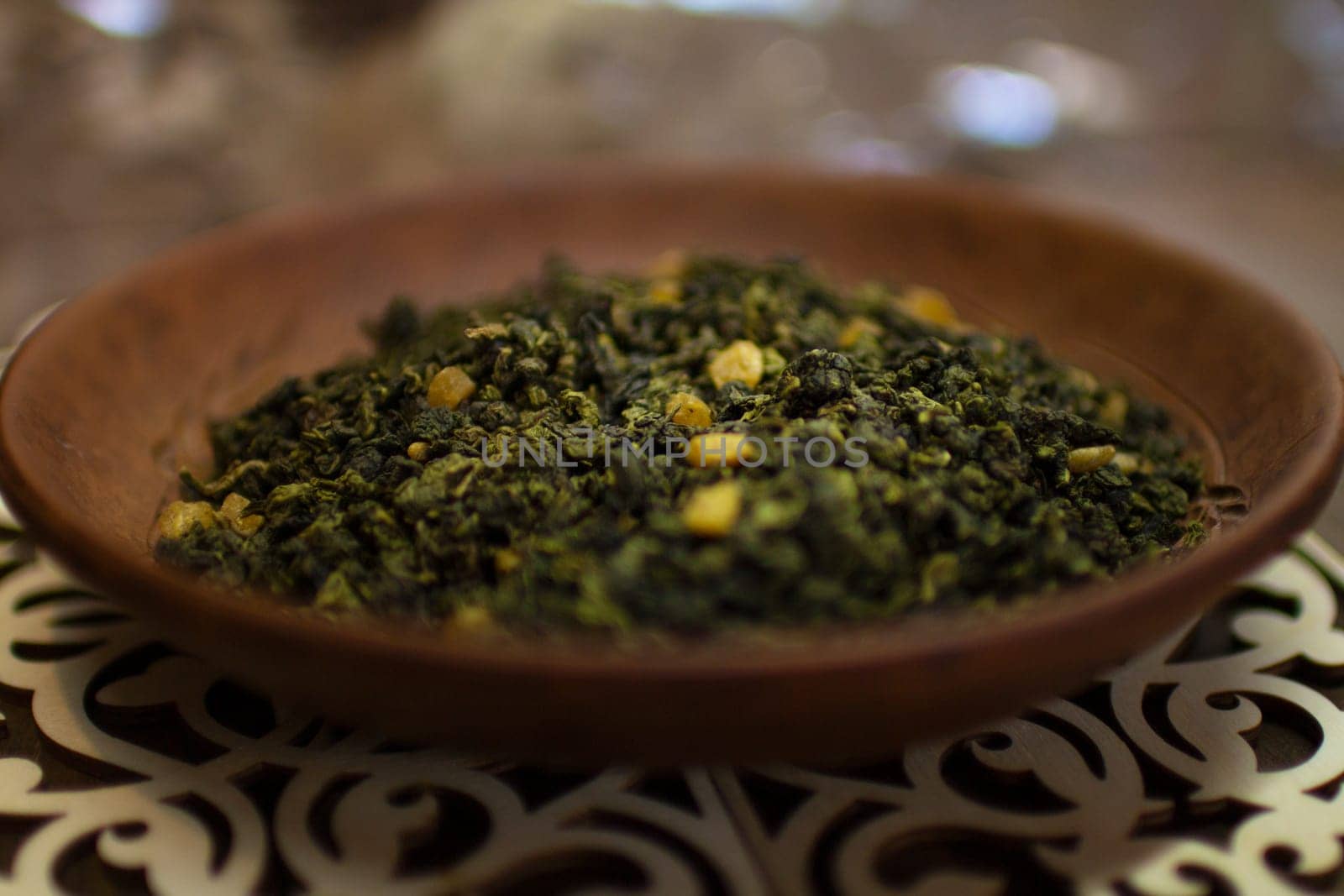 A clay plate with green fruit tea stands on a wooden table. High quality photo