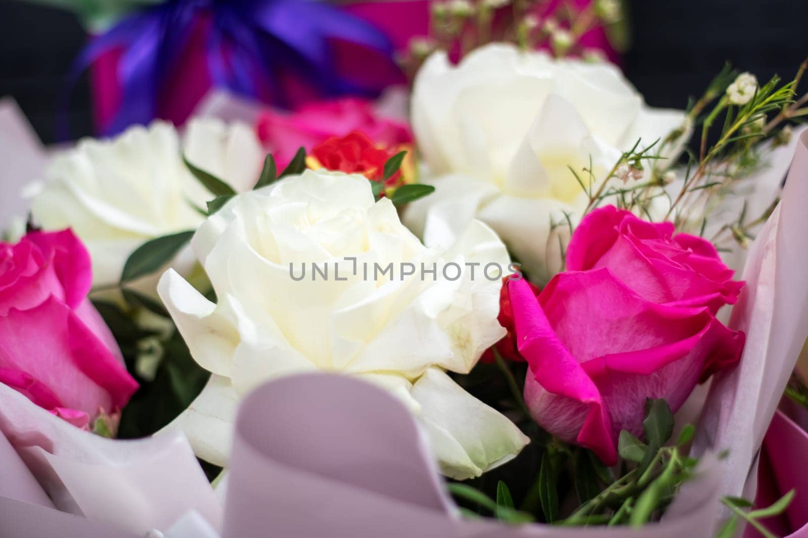A beautiful arrangement of white and pink roses elegantly presented in pink wrapping paper, perfect for any occasion that calls for a touch of natural beauty