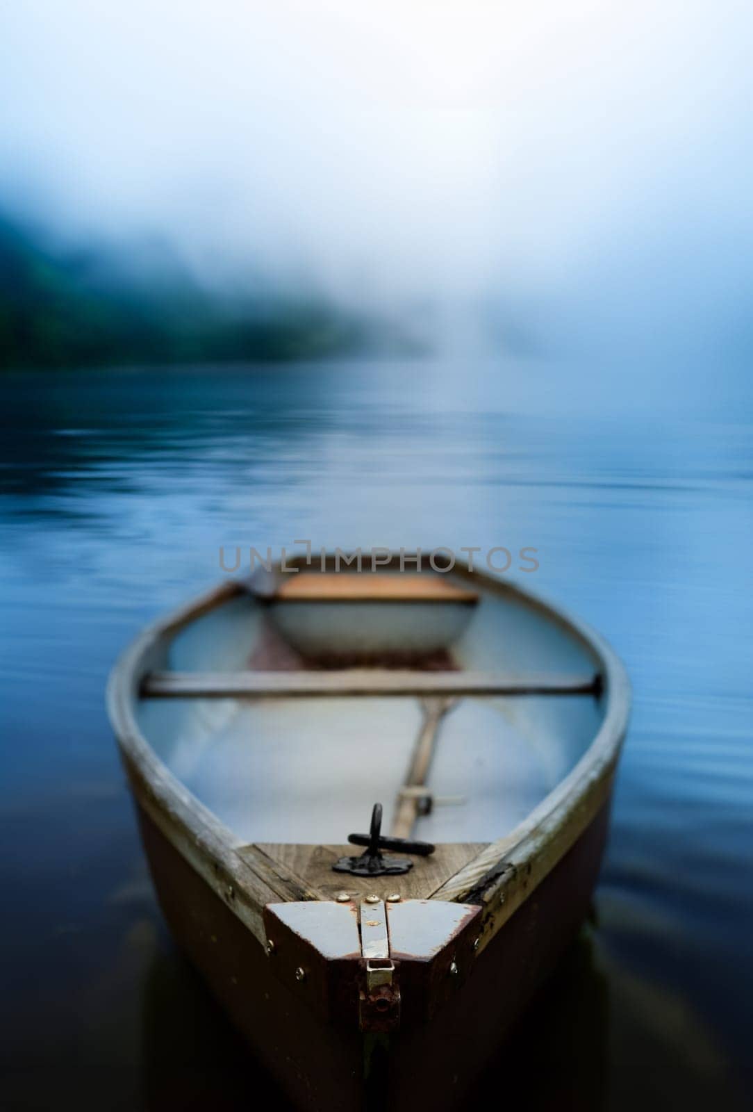 A Rustic Old Rowboat Beside On A Misty Lake At Dawn, With Shallow Focus And Copy-Space