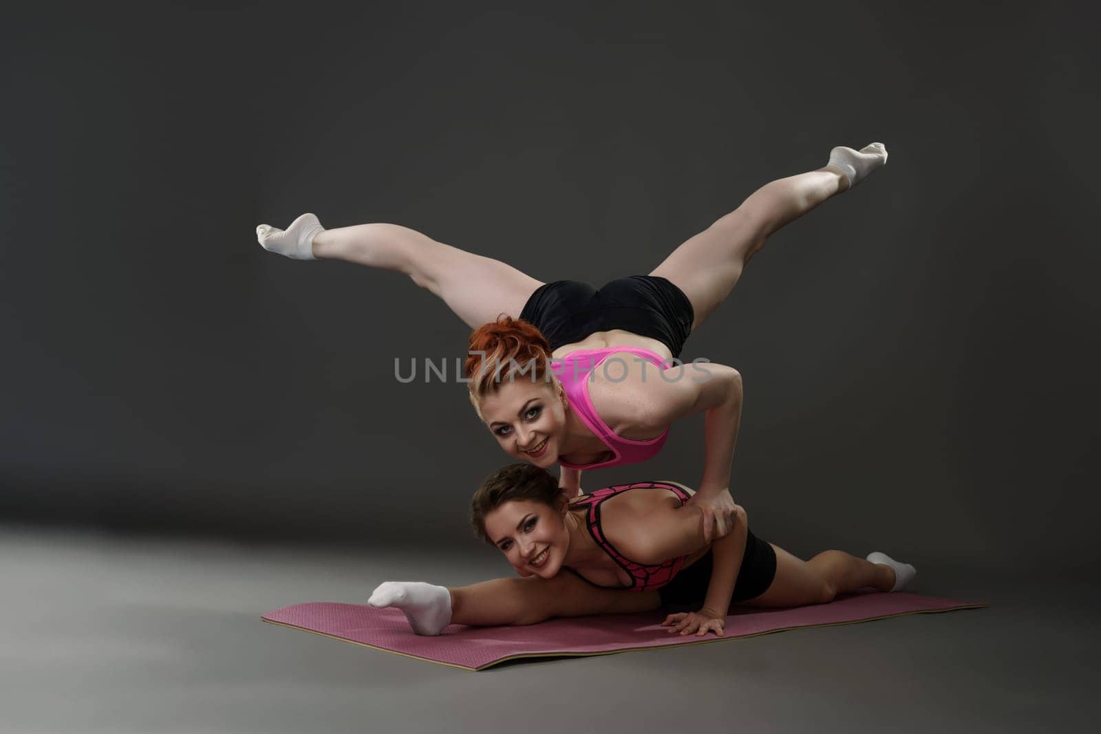 Photo of sports women pose during exercise, on gray background