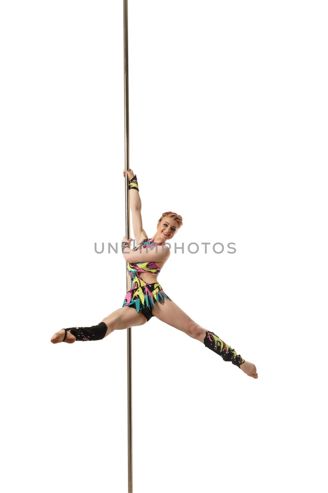 Image of red-haired woman posing while dancing on pylon
