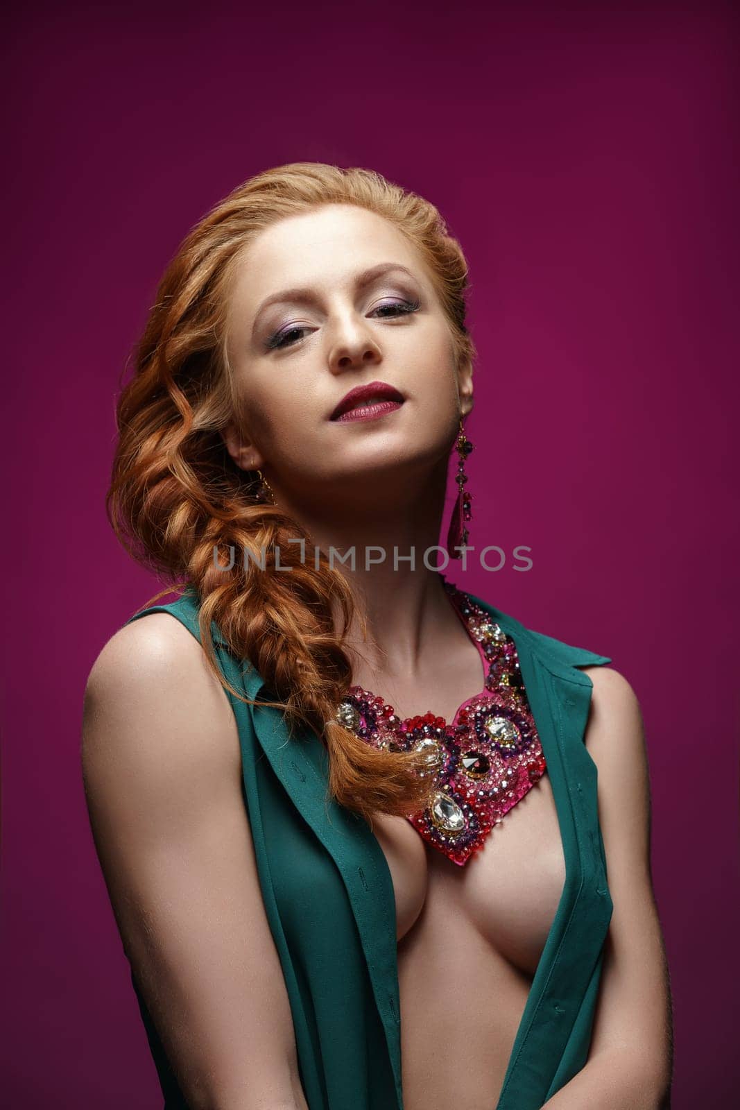 Studio photo of sexy redhead woman posing in jewelry