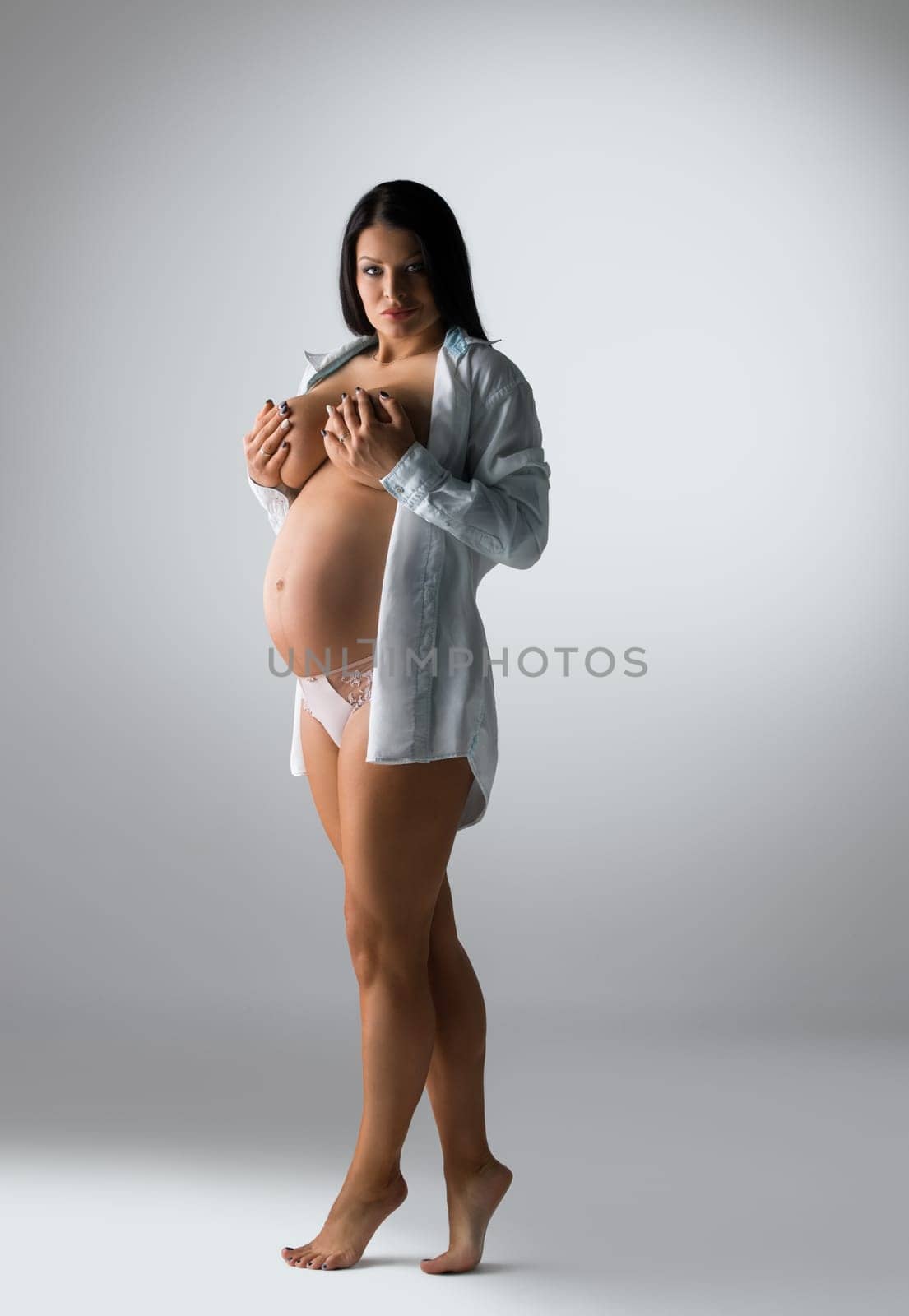 Full length photo of beautiful pregnant woman poses topless