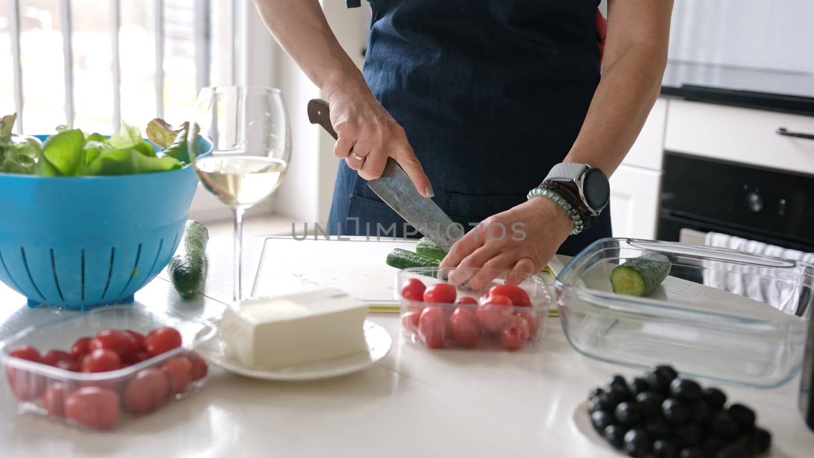Female Hands Slicing Cucumber For Greek Salad by tan4ikk1