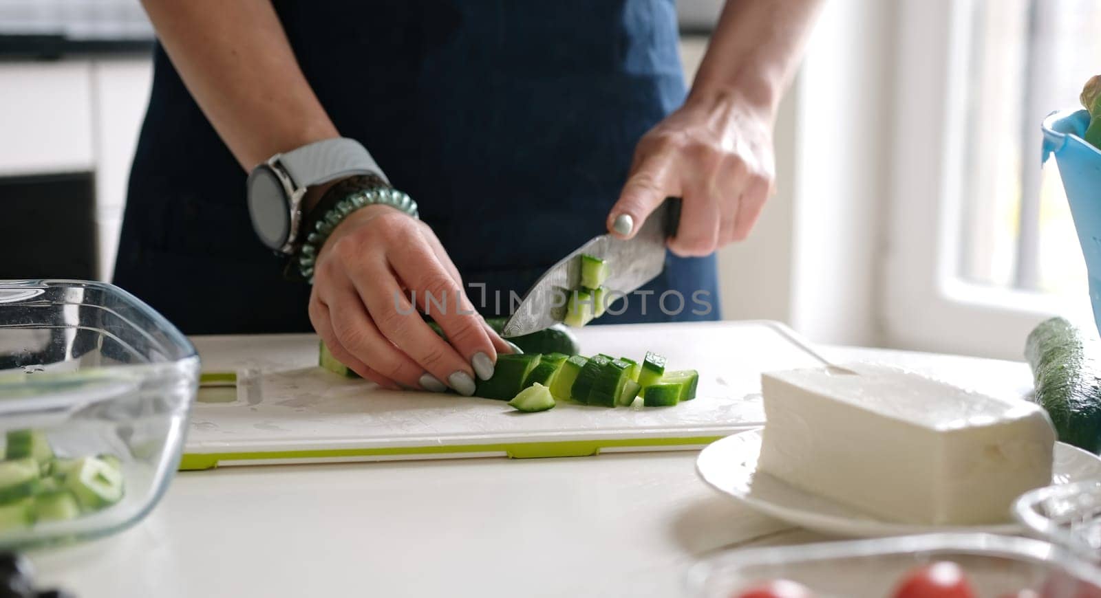 Female Hands Slicing Cucumber For Greek Salad by tan4ikk1