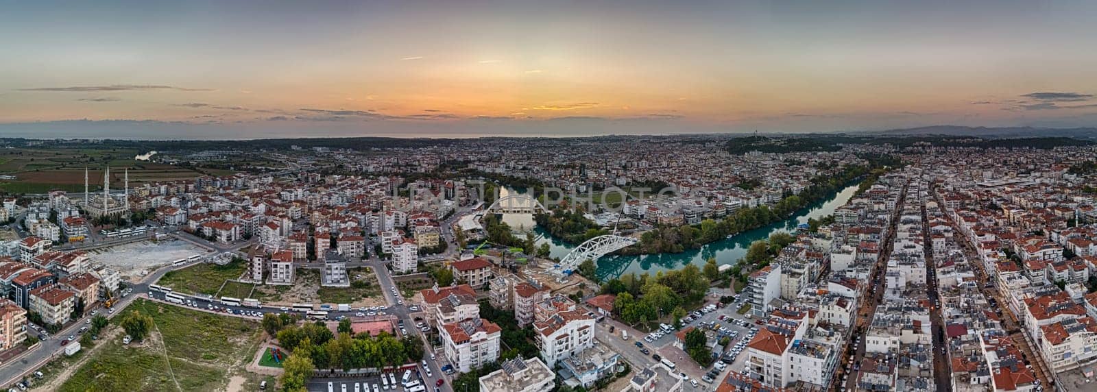 Aerial view of the city of Manavgat, the Manavgat River, the Mediterranean Sea, in the evening at sunset. Antalya region, Turkey.