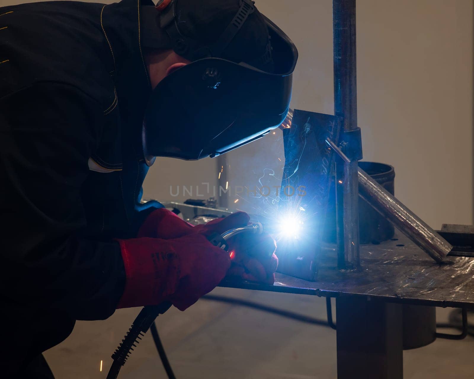 Competitions among welders. A man in a protective mask is welding