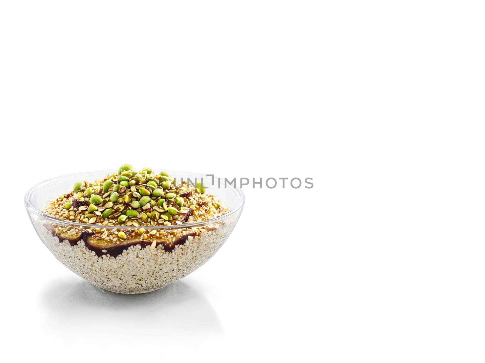 Porridge fig and honey with a sprinkle of crushed pistachios in a transparent glass bowl. Food isolated on transparent background.