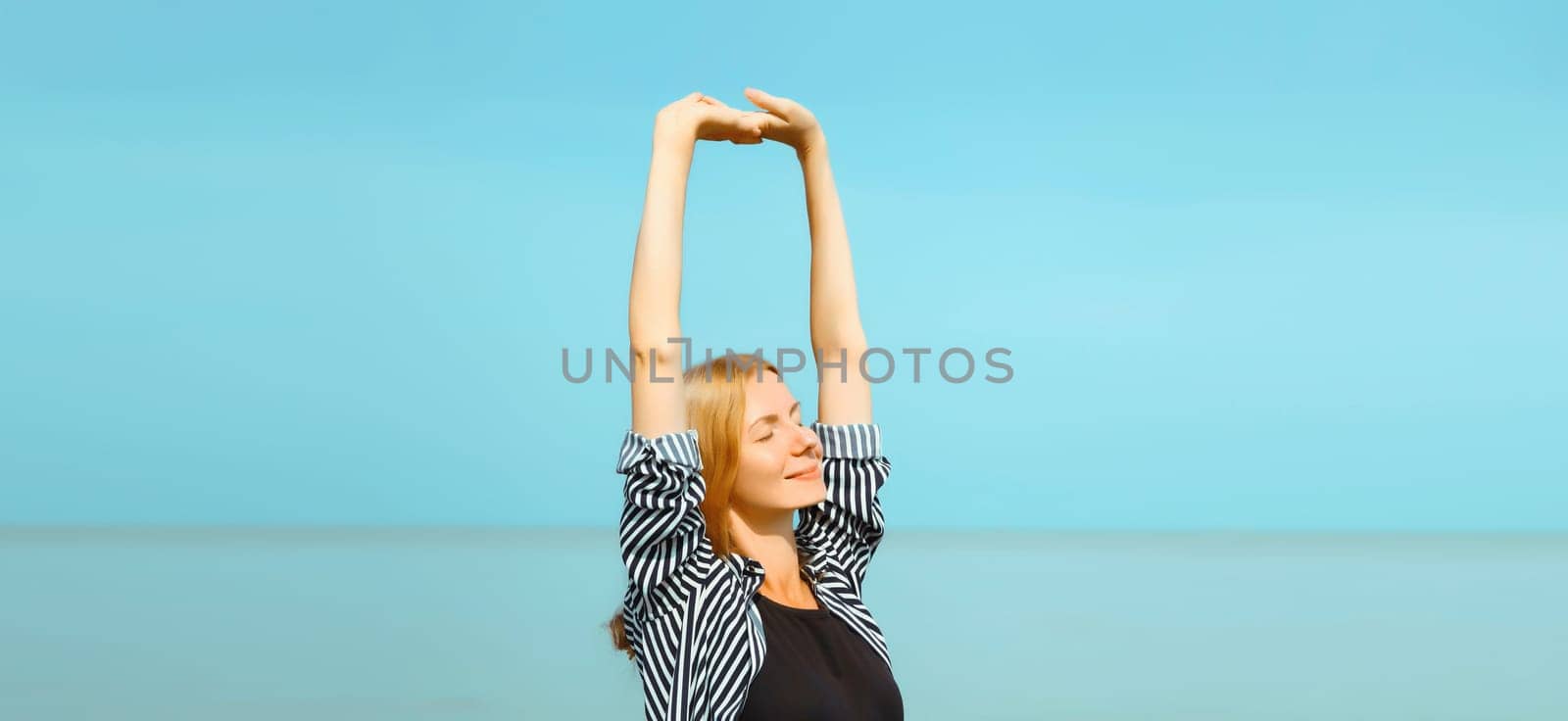 Summer vacation, happy relaxing woman meditates on the beach on sea by Rohappy