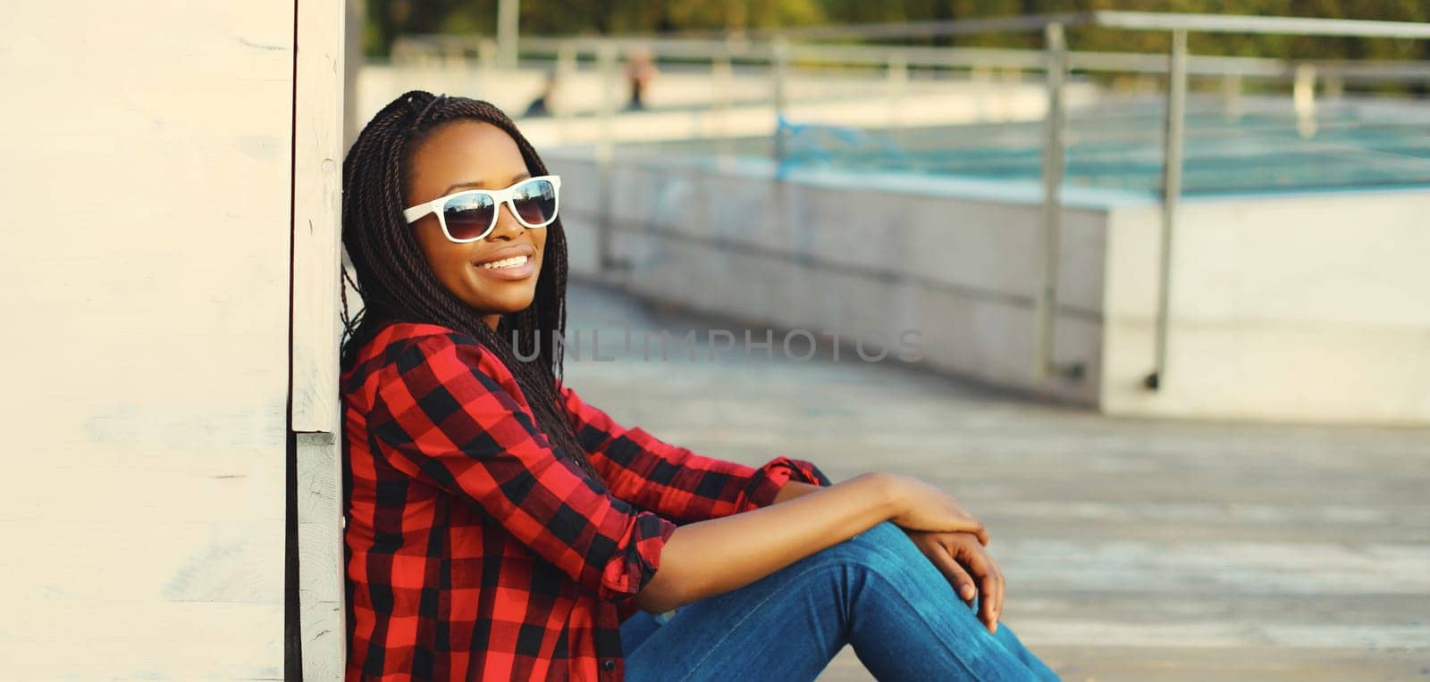 Portrait of stylish young african woman with dreadlocks posing wearing casual in the city by Rohappy